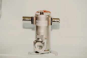 A metallic cylindrical object with two side connectors