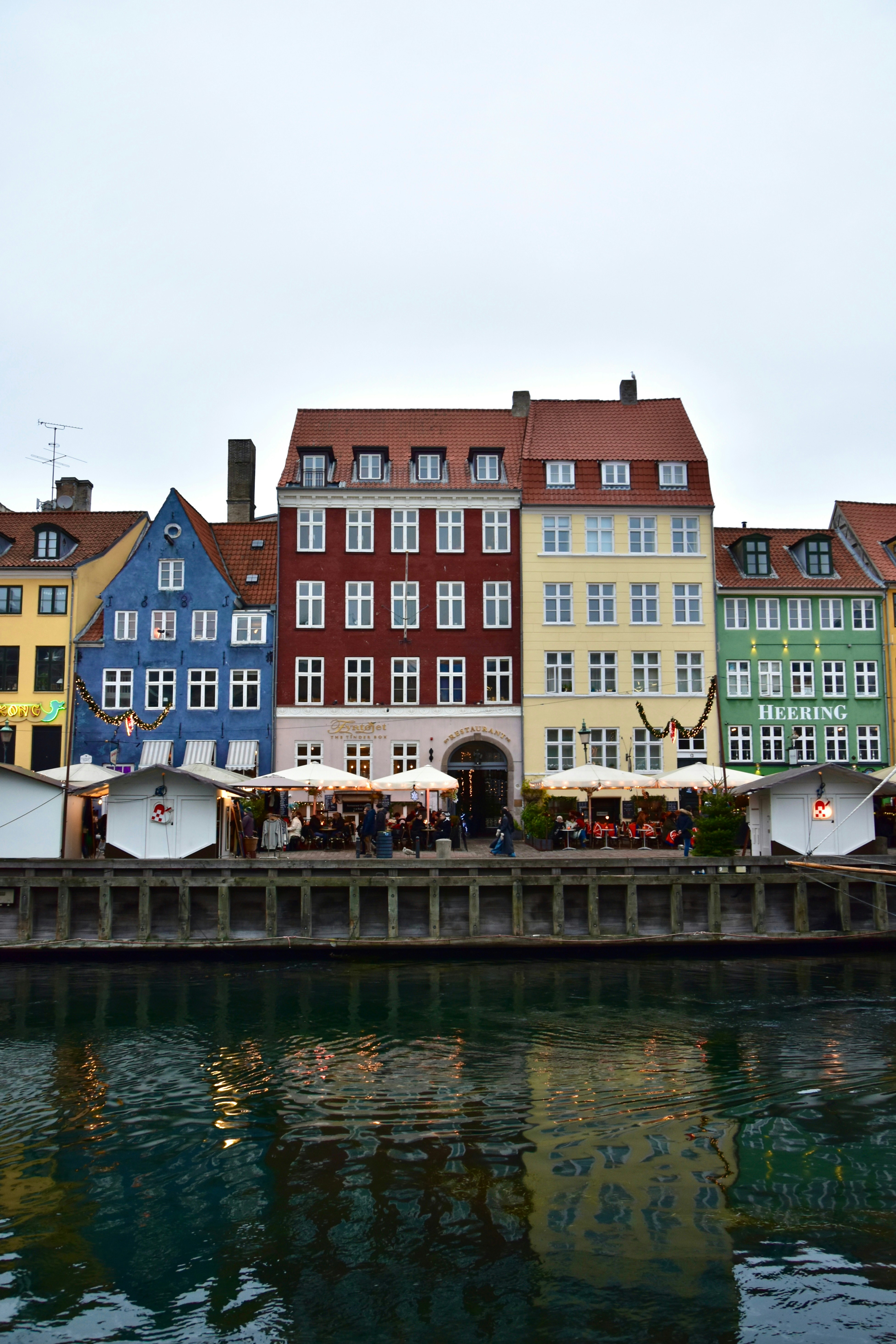 Colorful buildings line a canal with outdoor seating.
