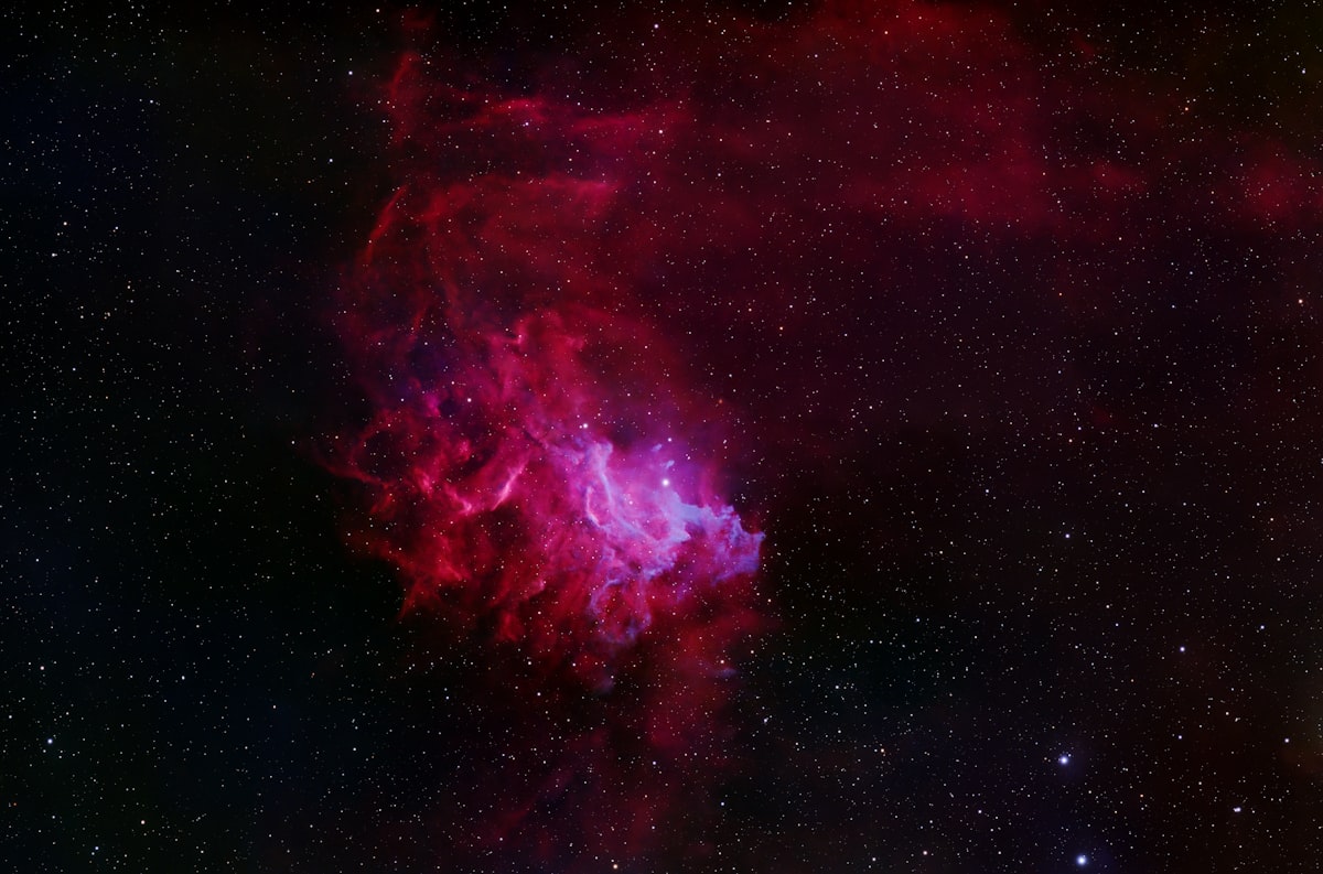 The Flaming Star Nebula in the constellation Auriga, showing bright star AE Aurigae surrounded by red energized gas and blue reflected dust creating a flame-like appearance