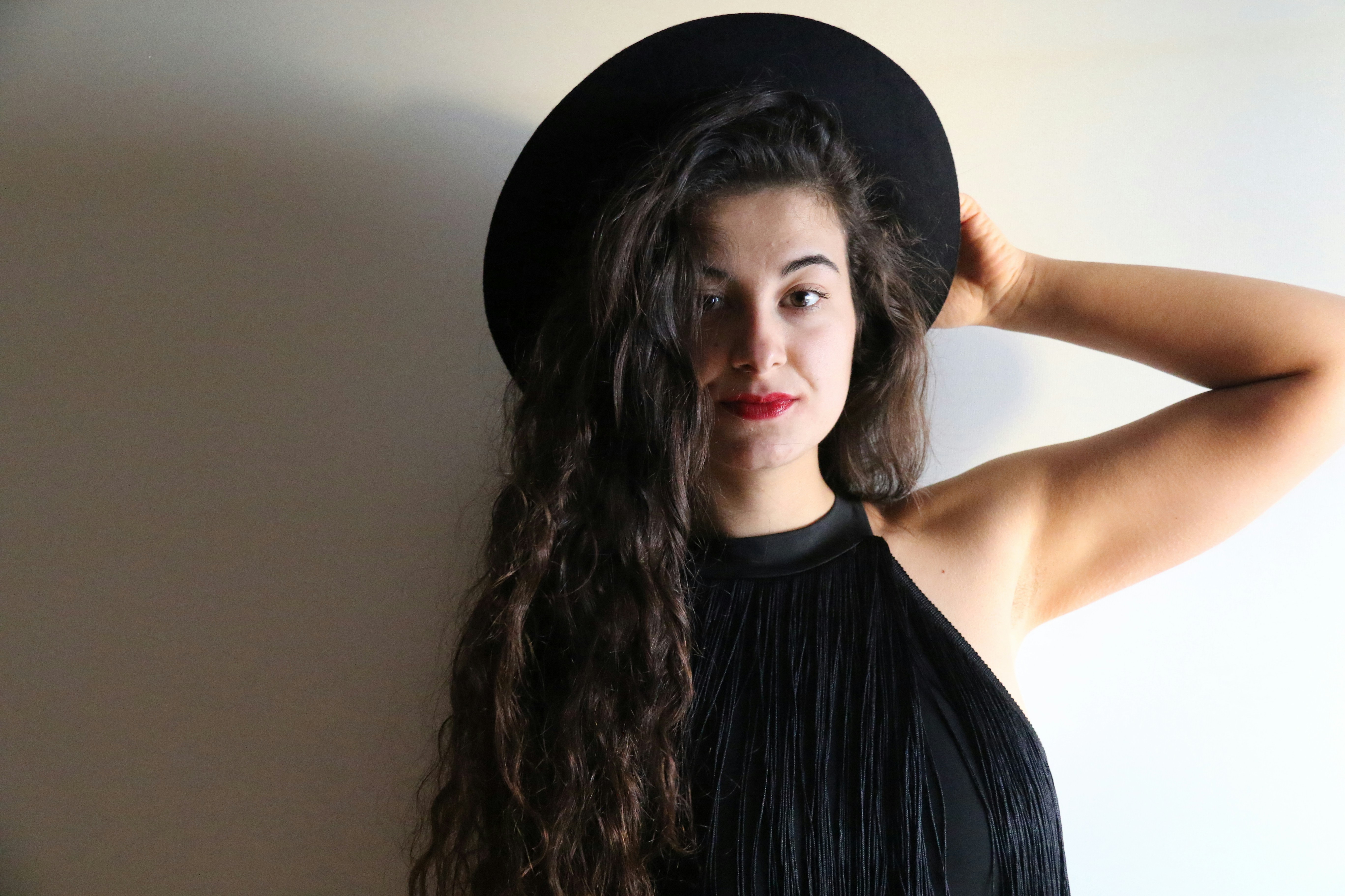 Young woman in black hat and fringe top
