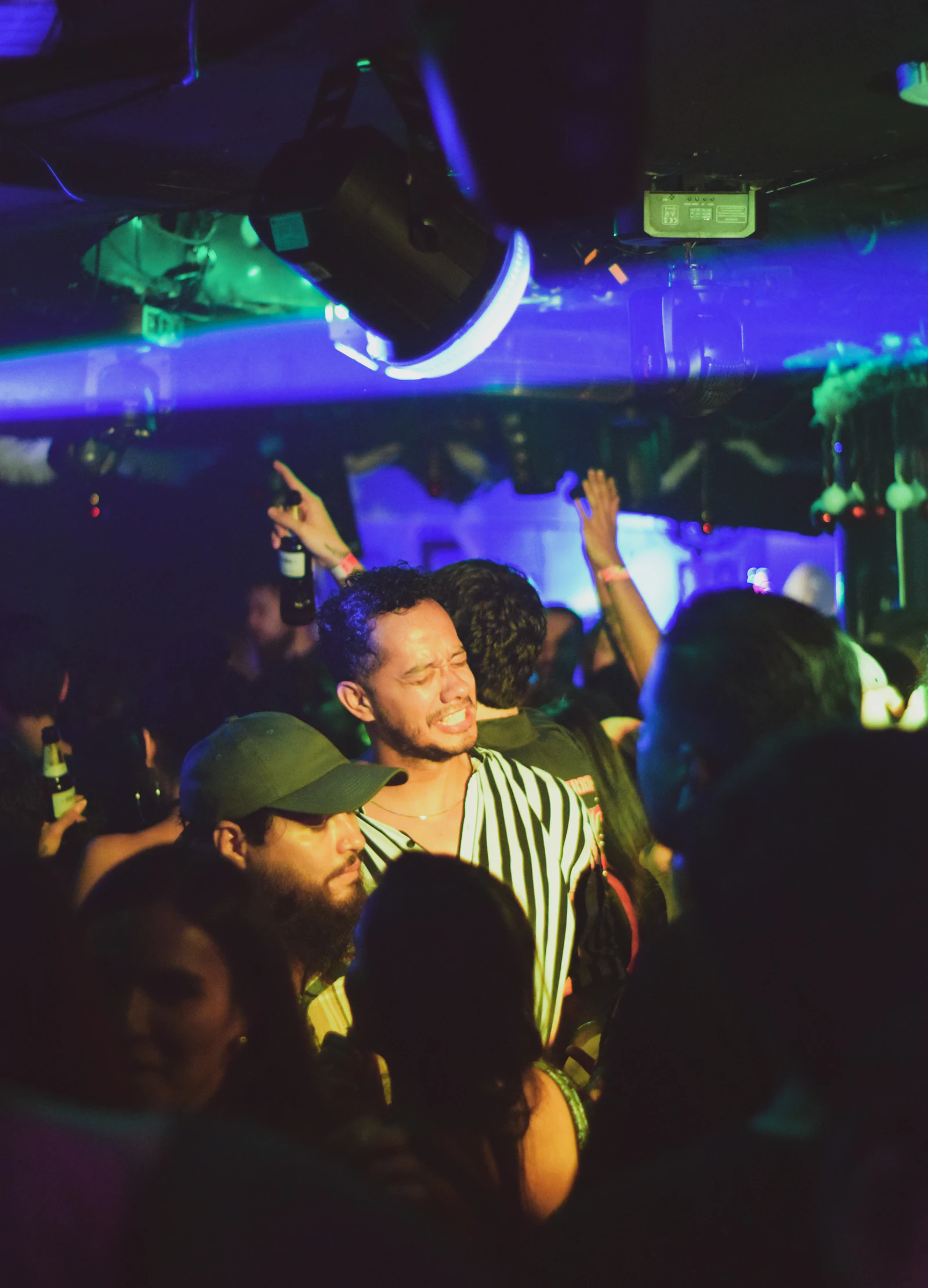 A packed night at the bar — crowd singing and dancing under the lights