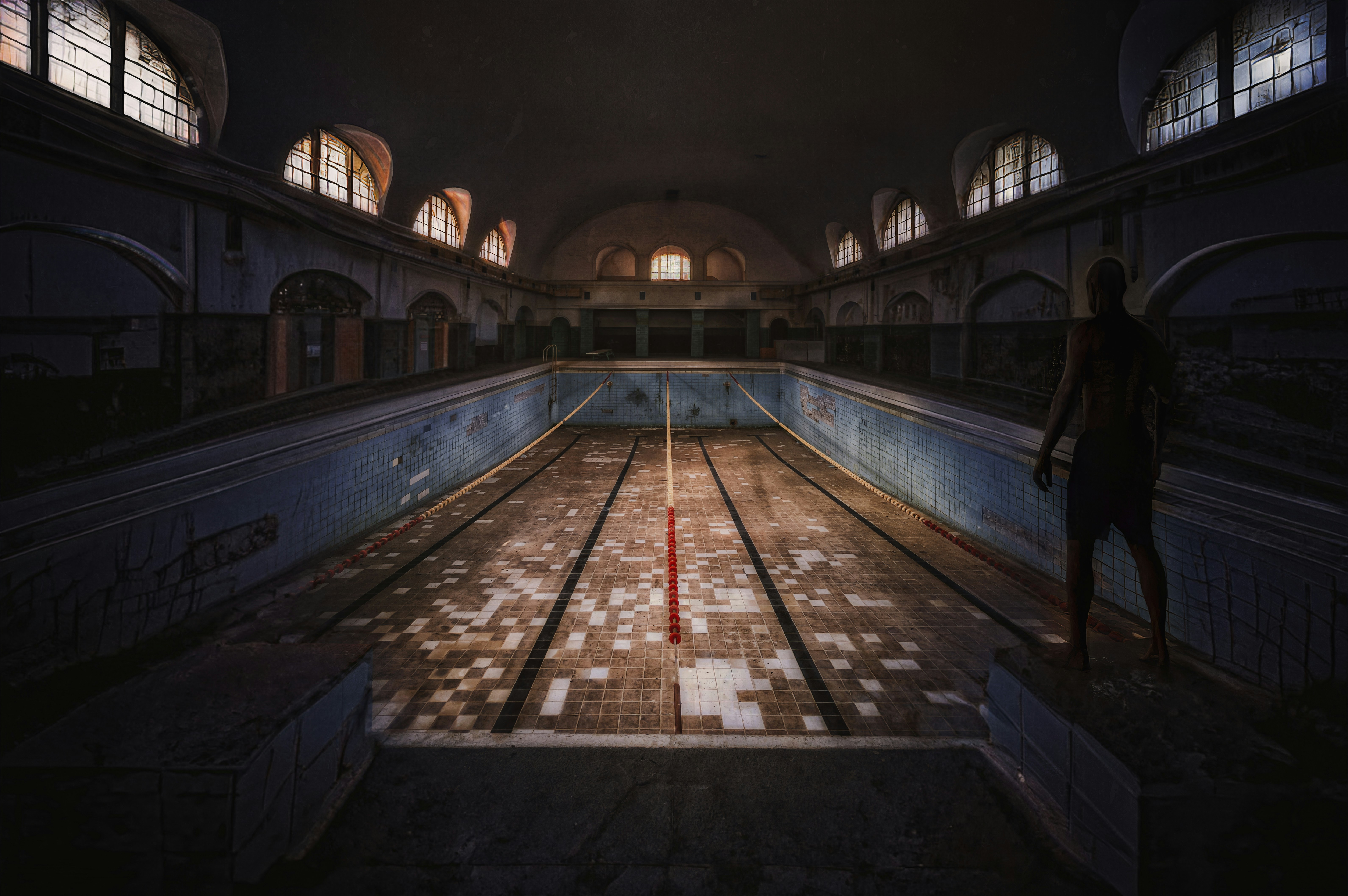 Piscina abbandonata con una figura solitaria