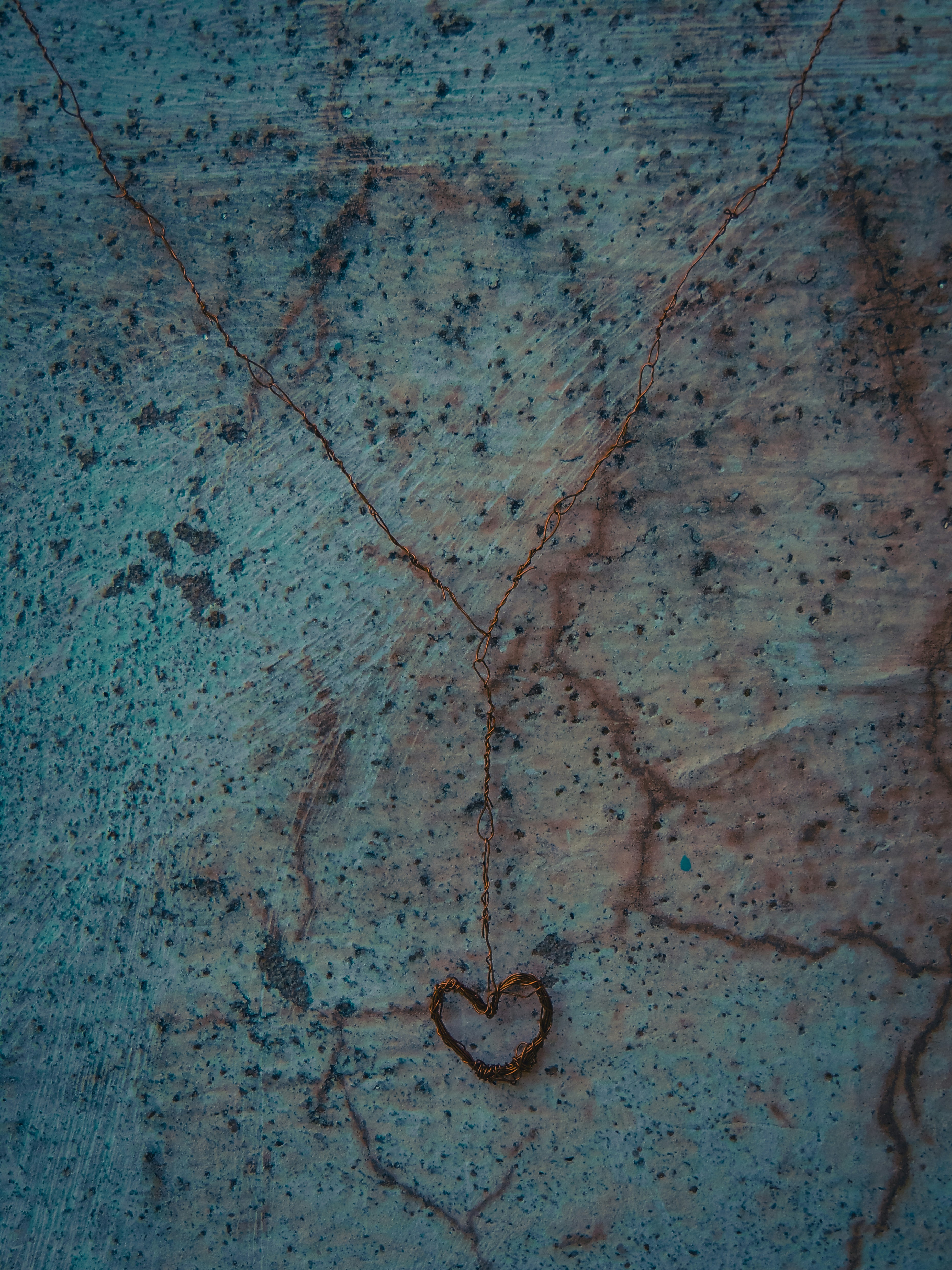 A small heart shape etched into a cracked wall.