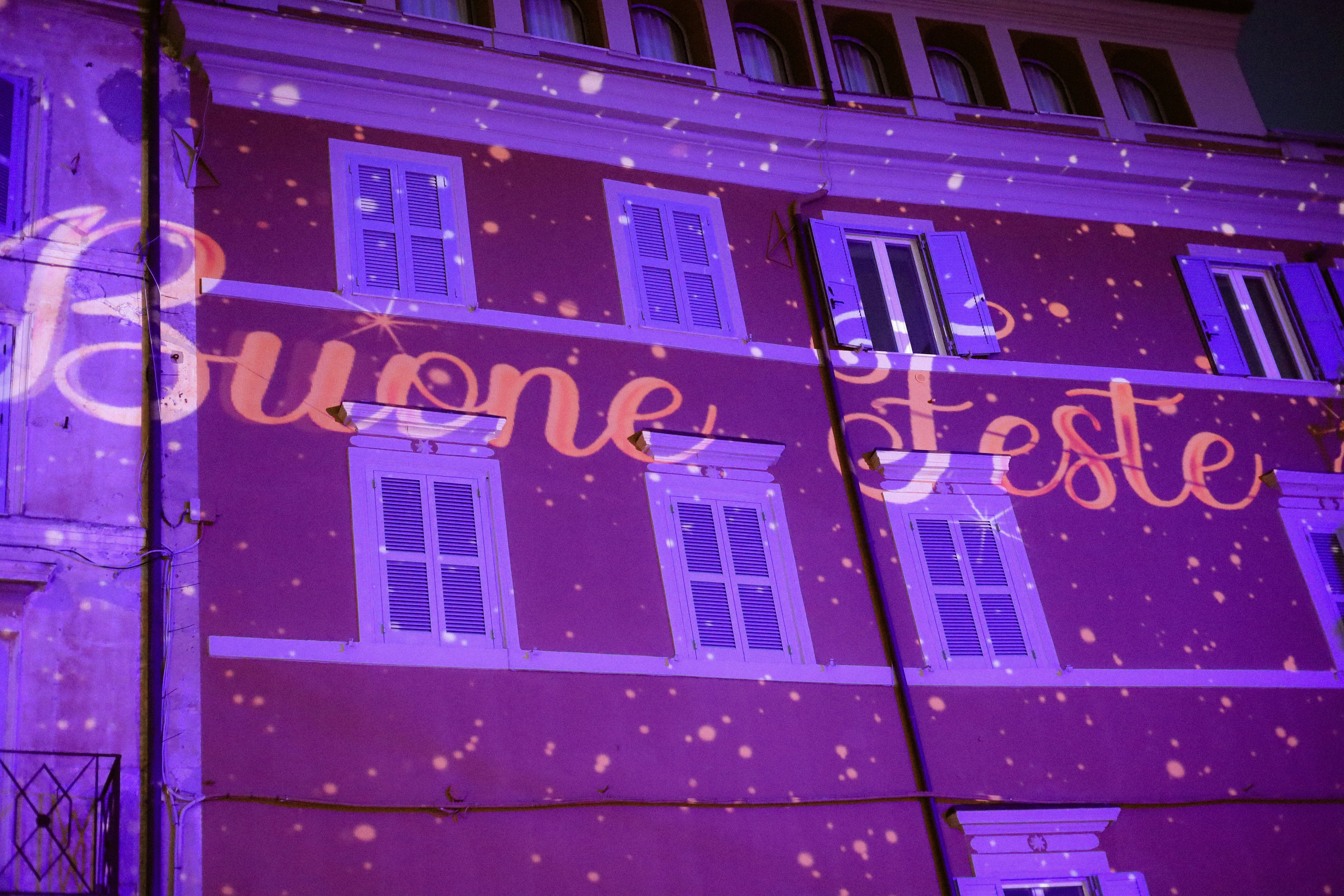 Building illuminated with "buone feste" projection