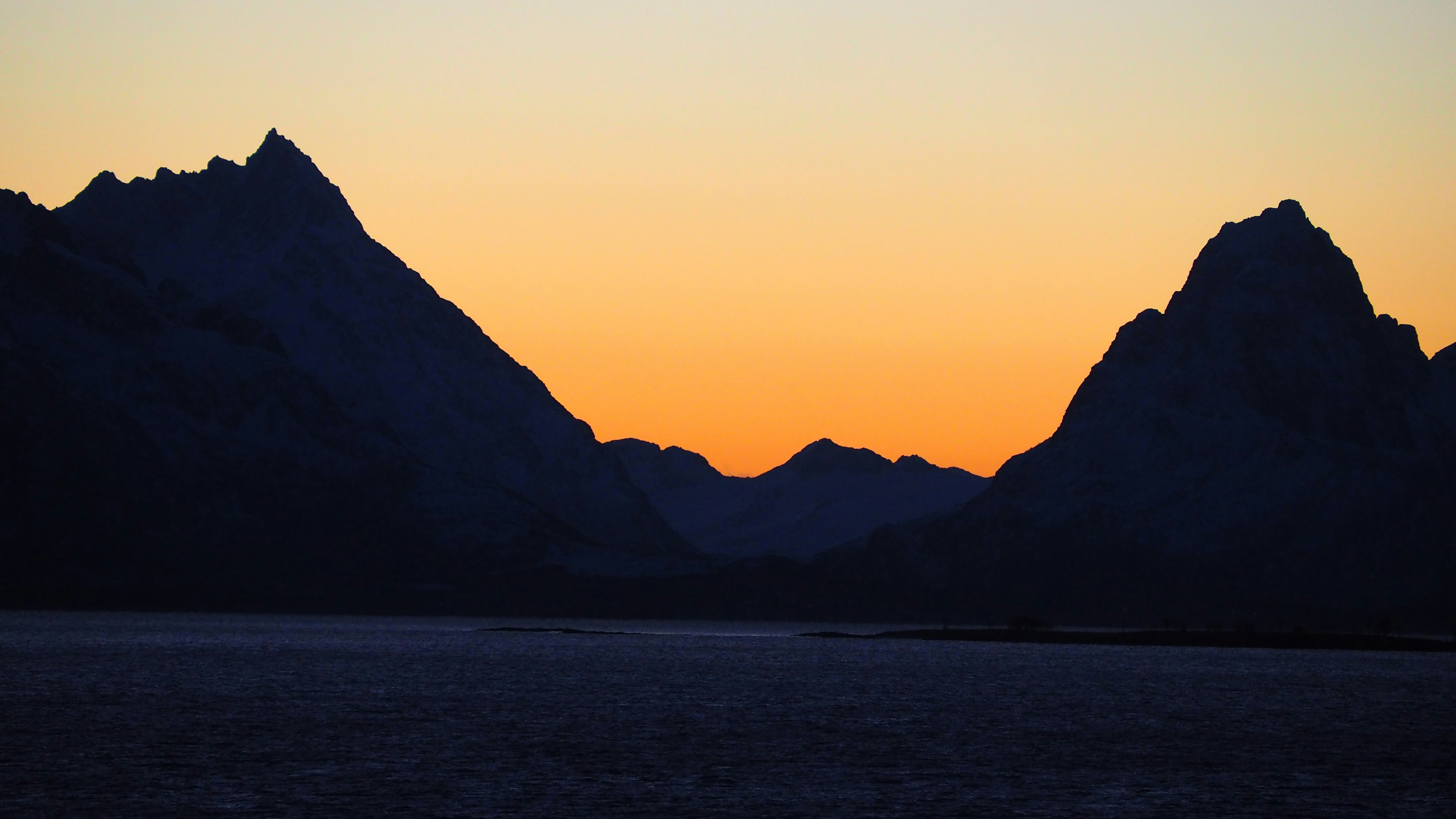 Silhouette of mountains against an orange sky