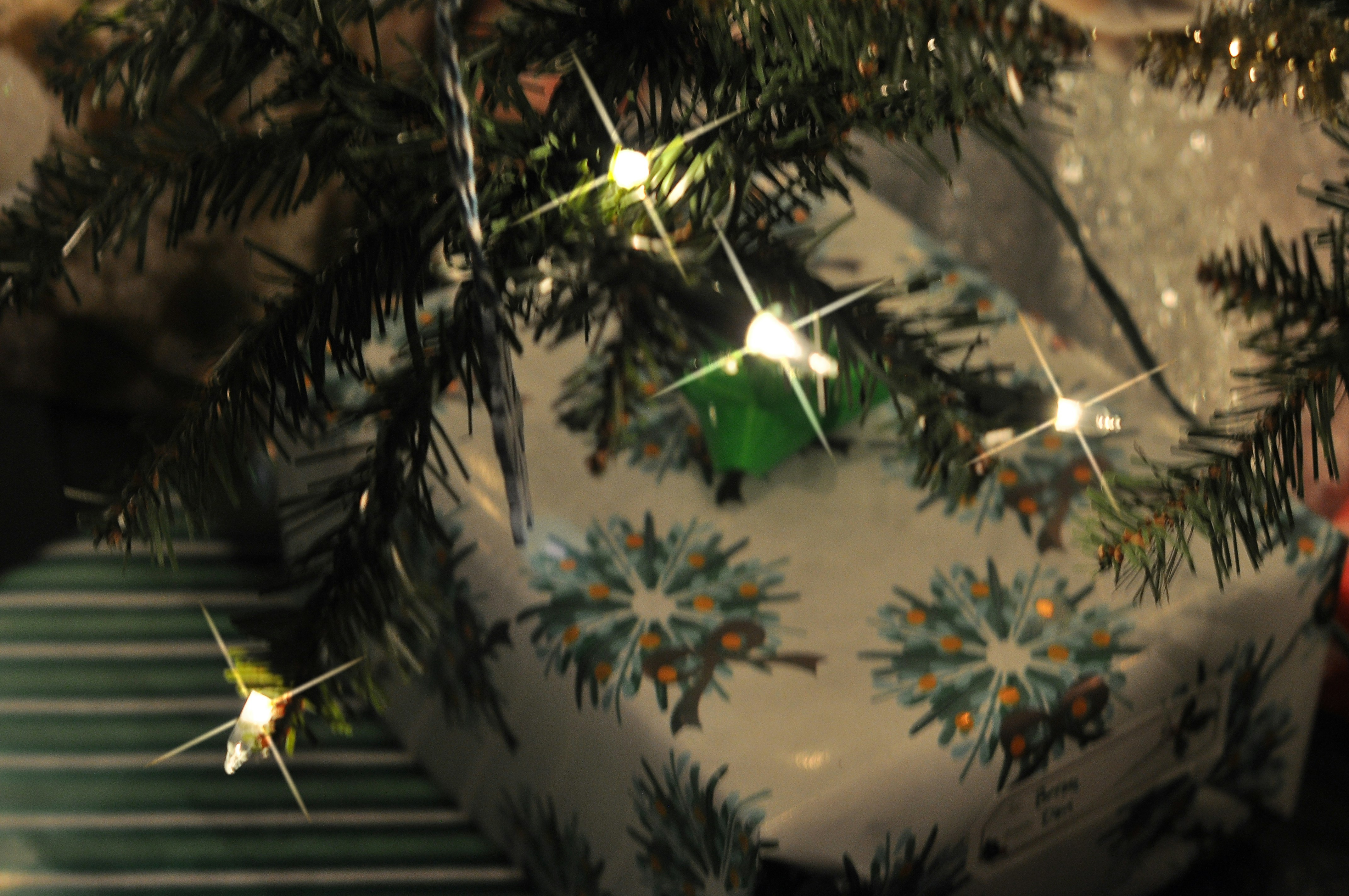 Christmas tree with decorated presents and lit presents.