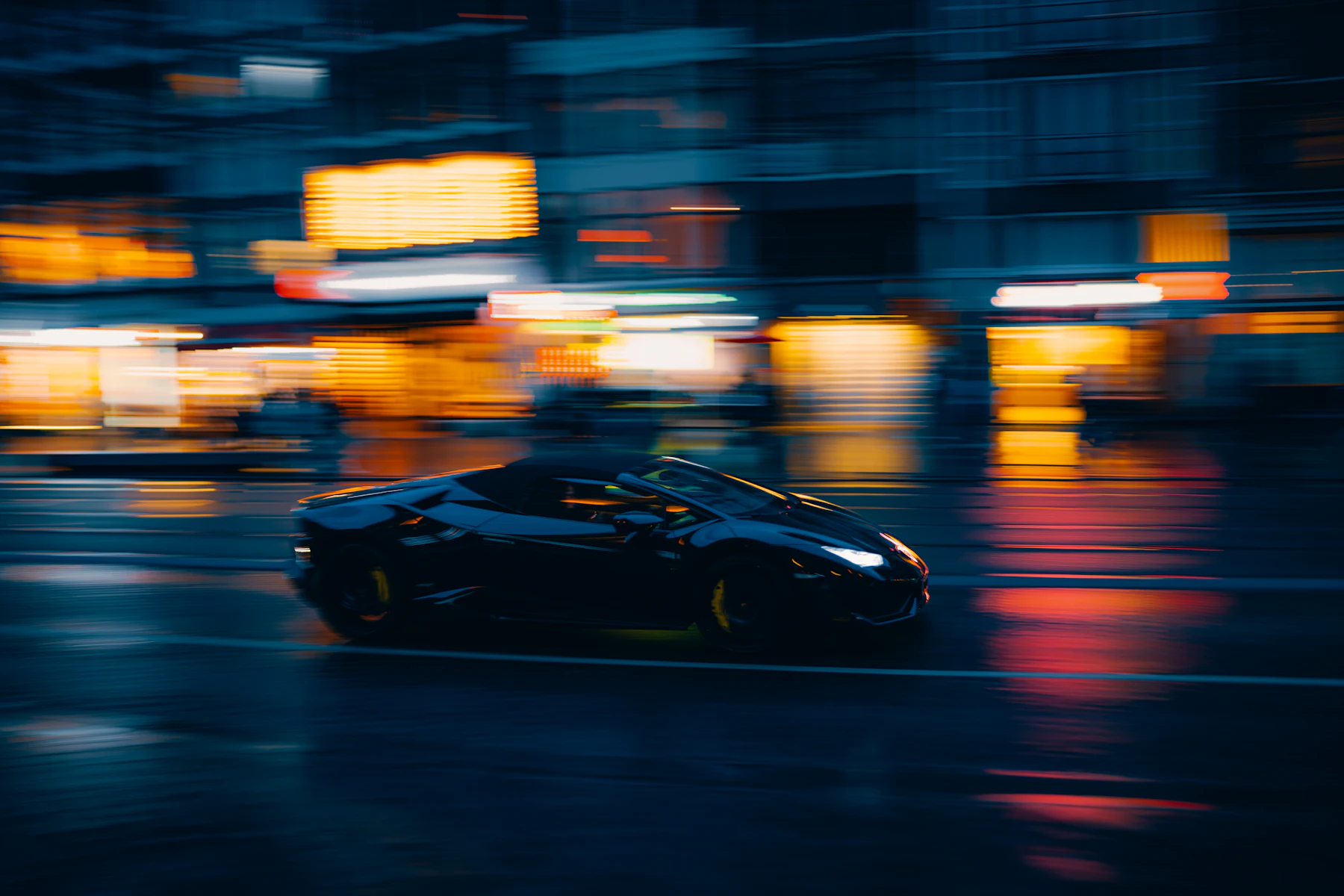A performance car in motion through the city at night