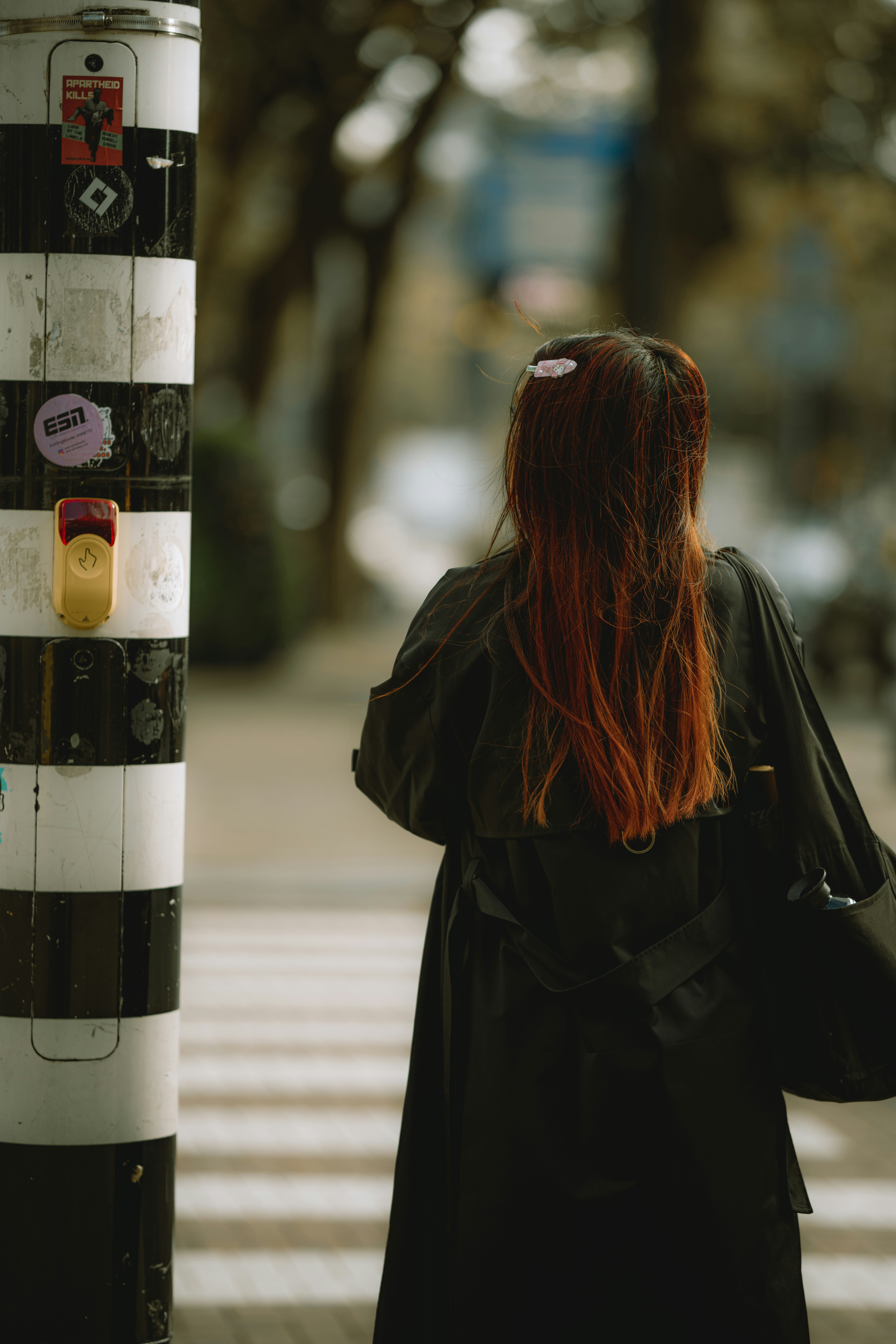 Woman with red hair walks across a crosswalk