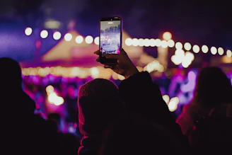 Person records concert with smartphone at night with phone