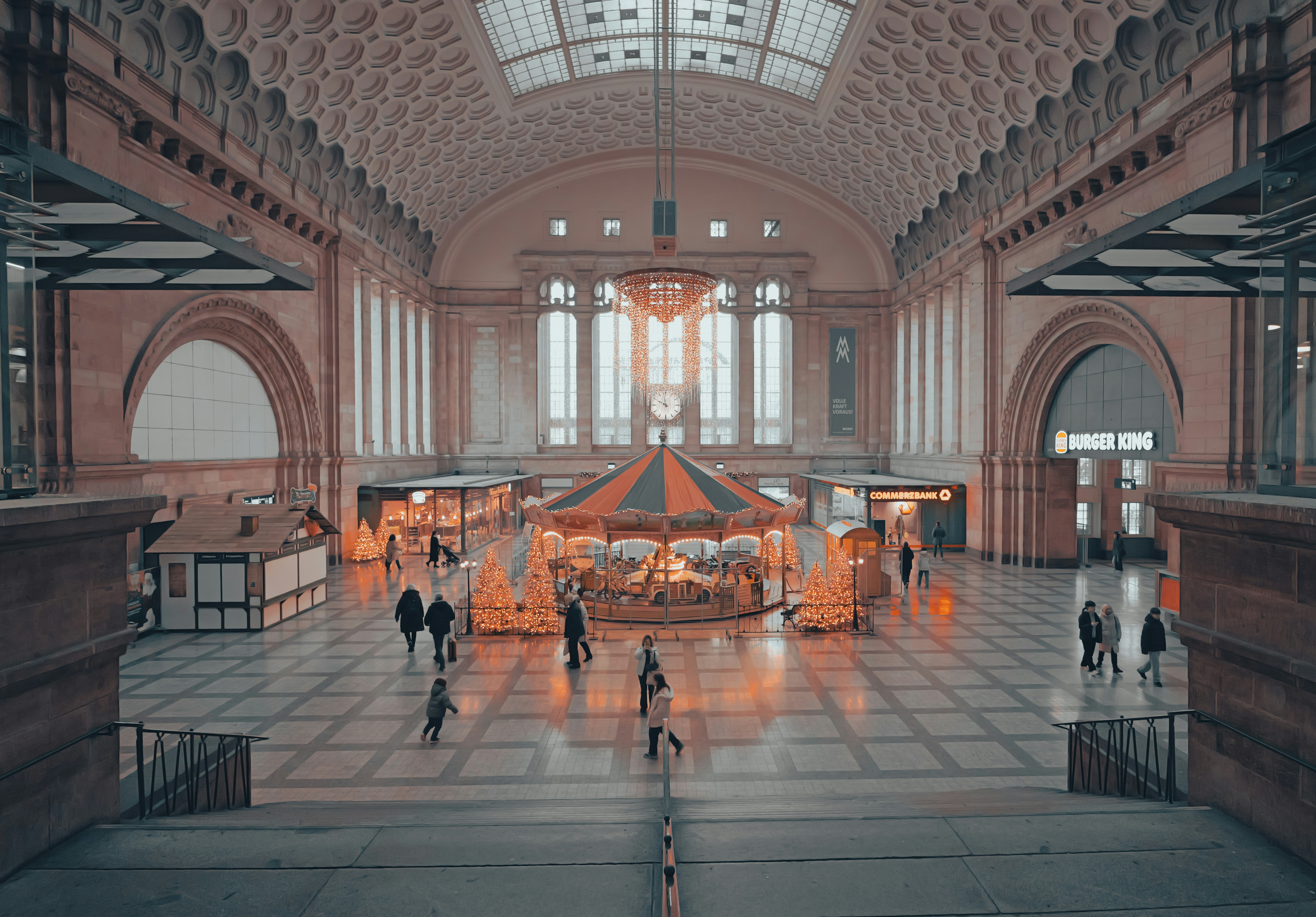 Grand interior of a vintage train station with carousel - grand-interior-of-a-vintage-train-station-with-carousel-SL2OQ0XH_gk