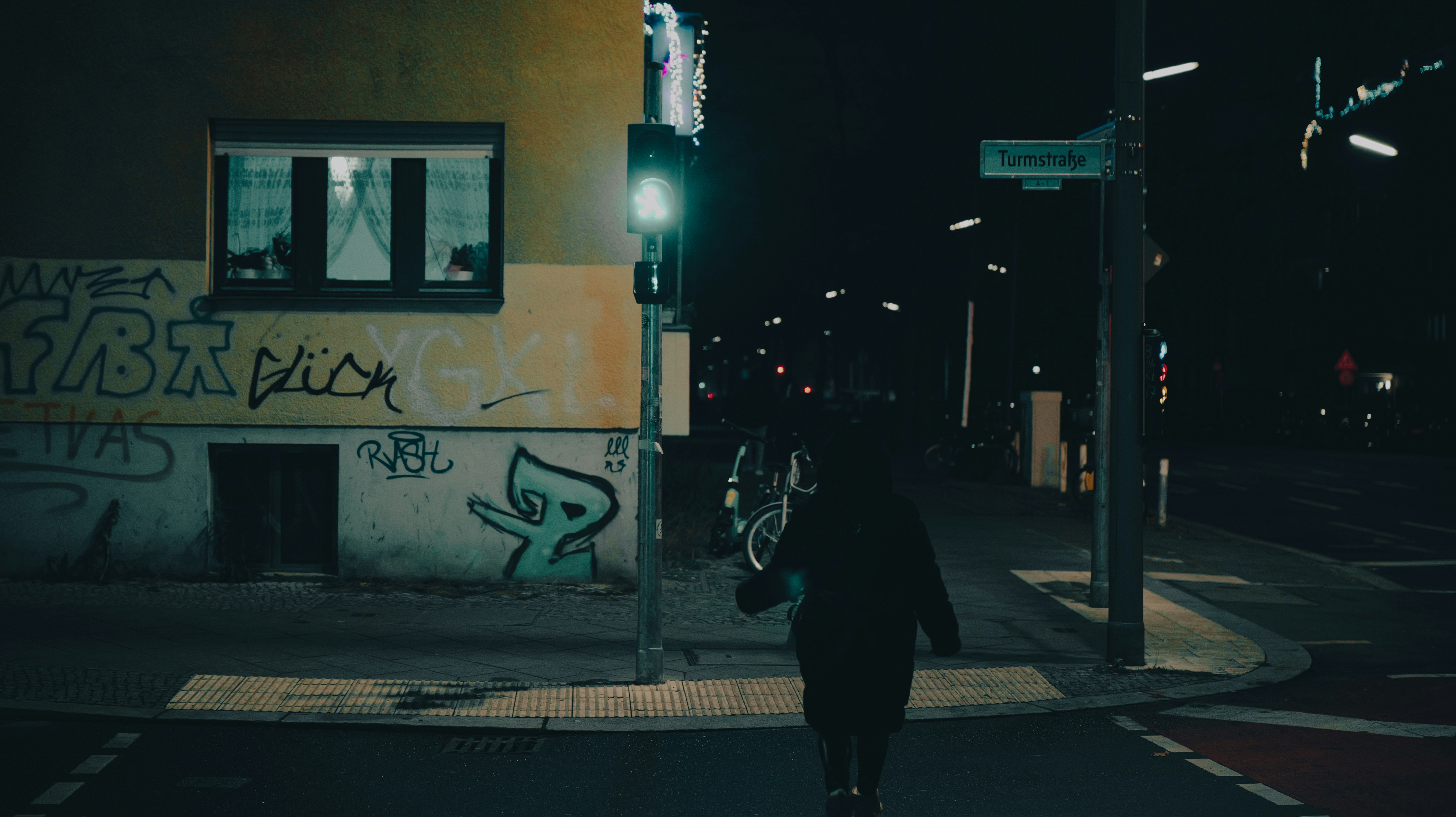 Person crossing street at night with traffic light. - person-crossing-street-at-night-with-traffic-light-fMVebeiG6WY