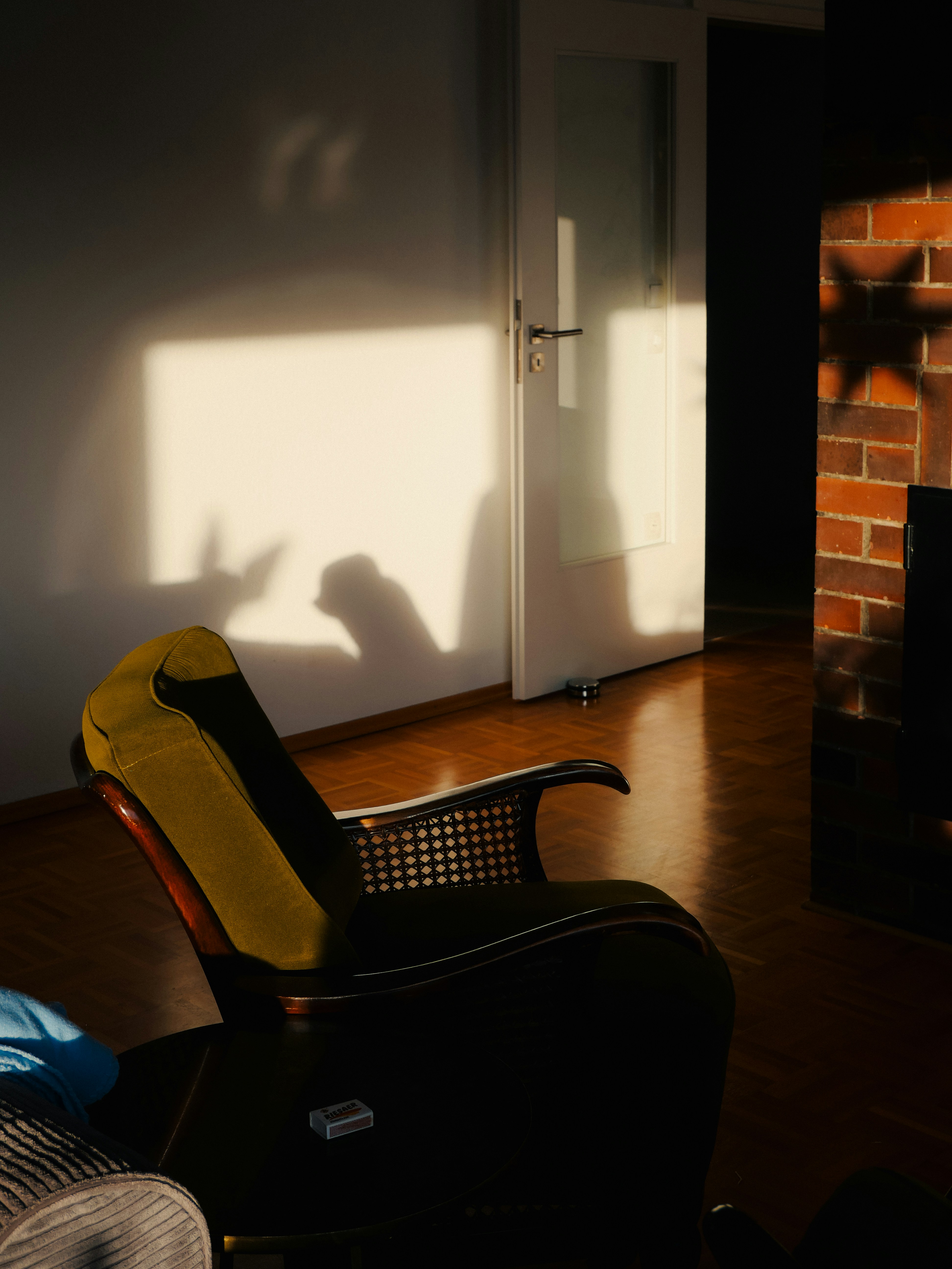 Sunlight streams into a room, casting shadows on the wall.