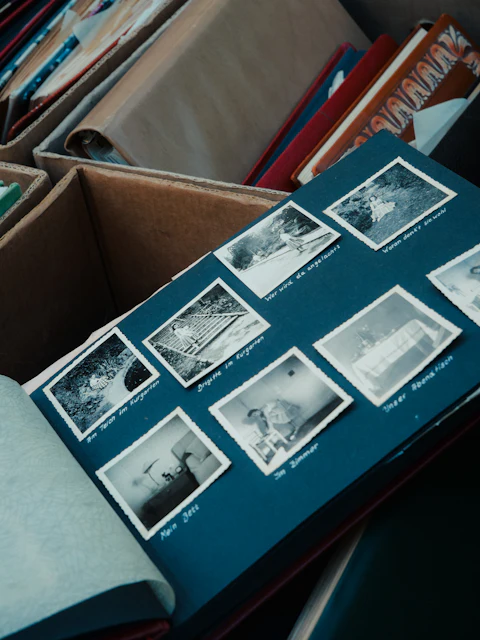 Old photographs arranged in a scrapbook alongside handwritten notes