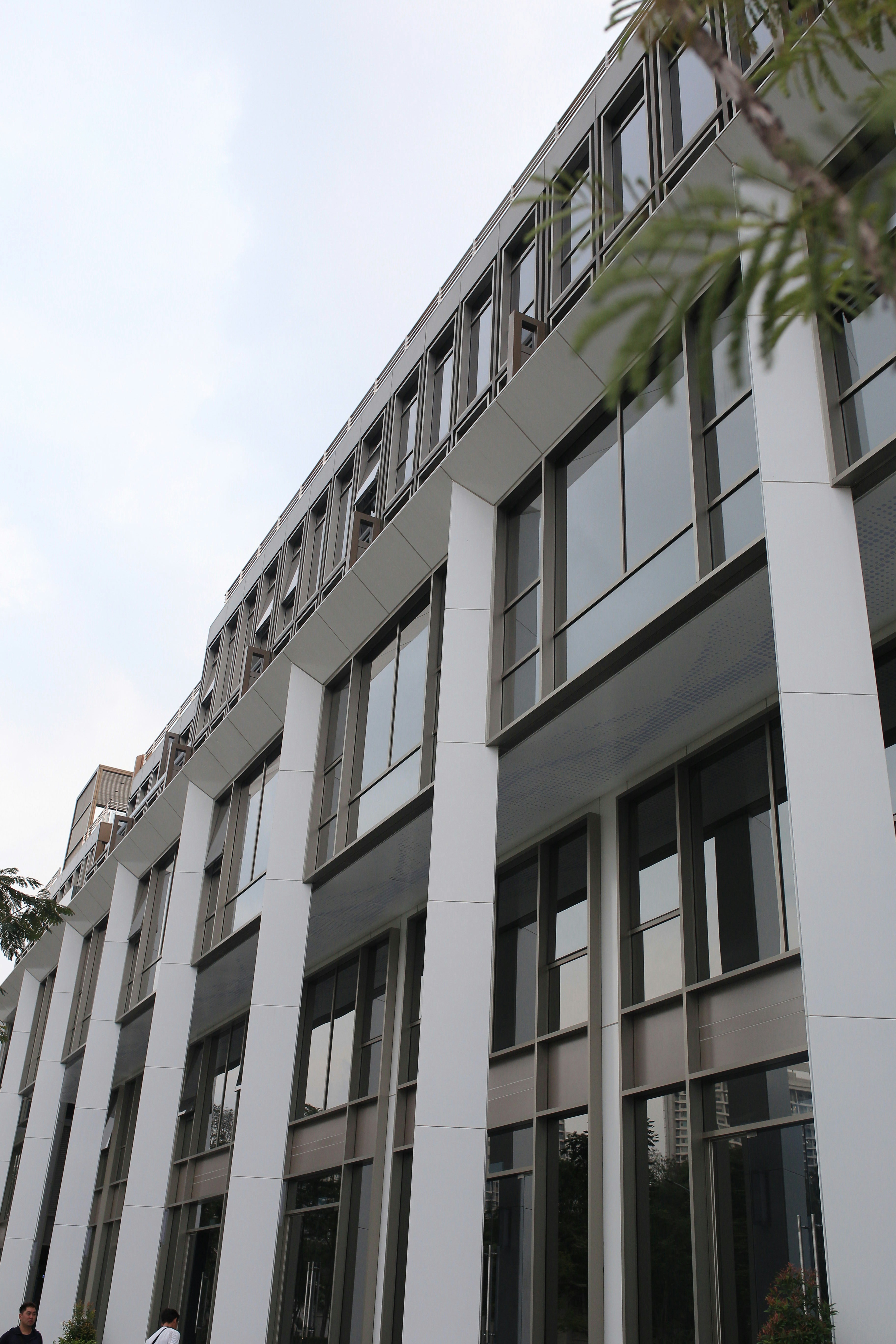 Contemporary corporate office building with glass facade and white structural columns