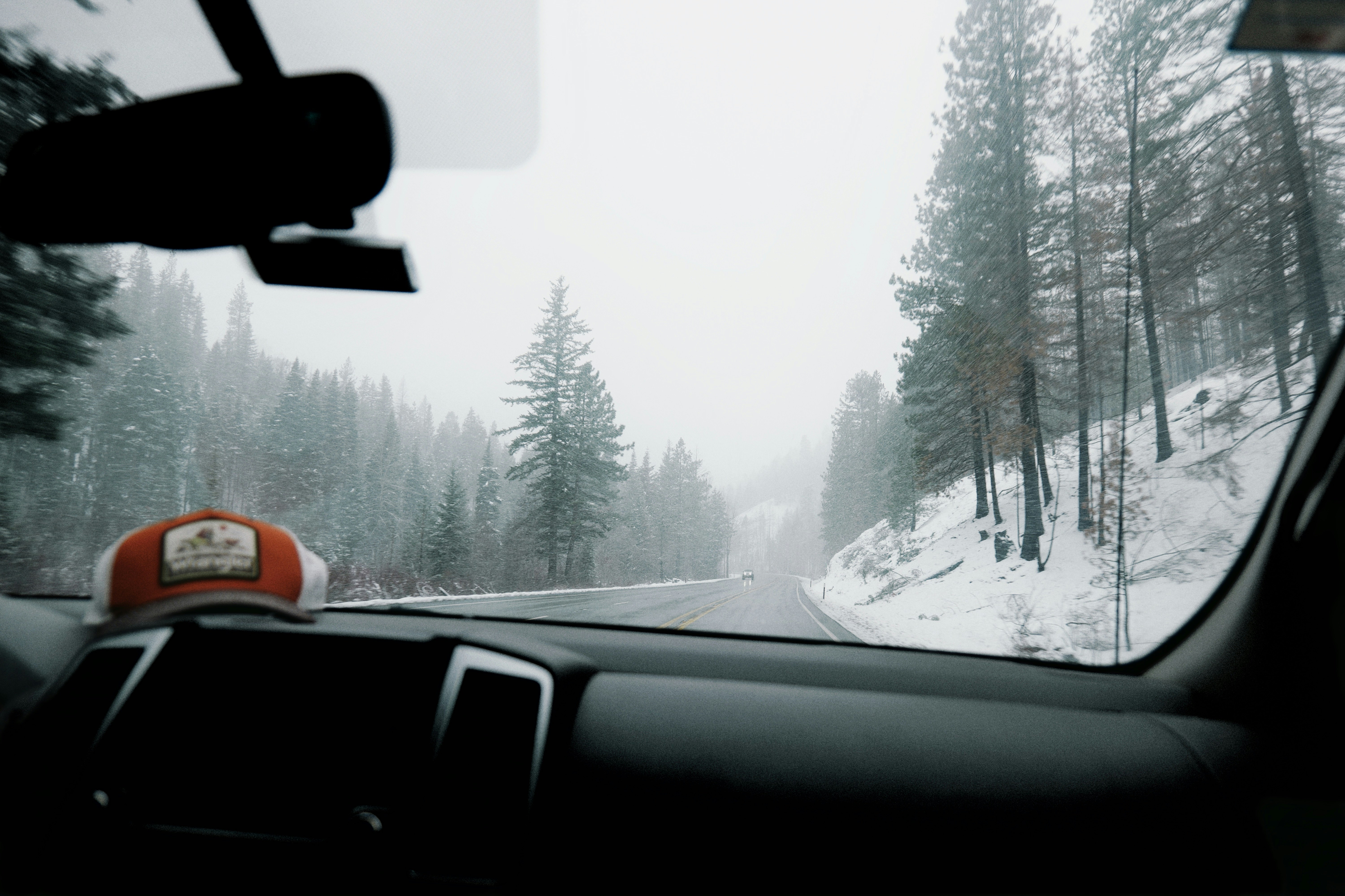 Driving on a snowy road through a winter forest.