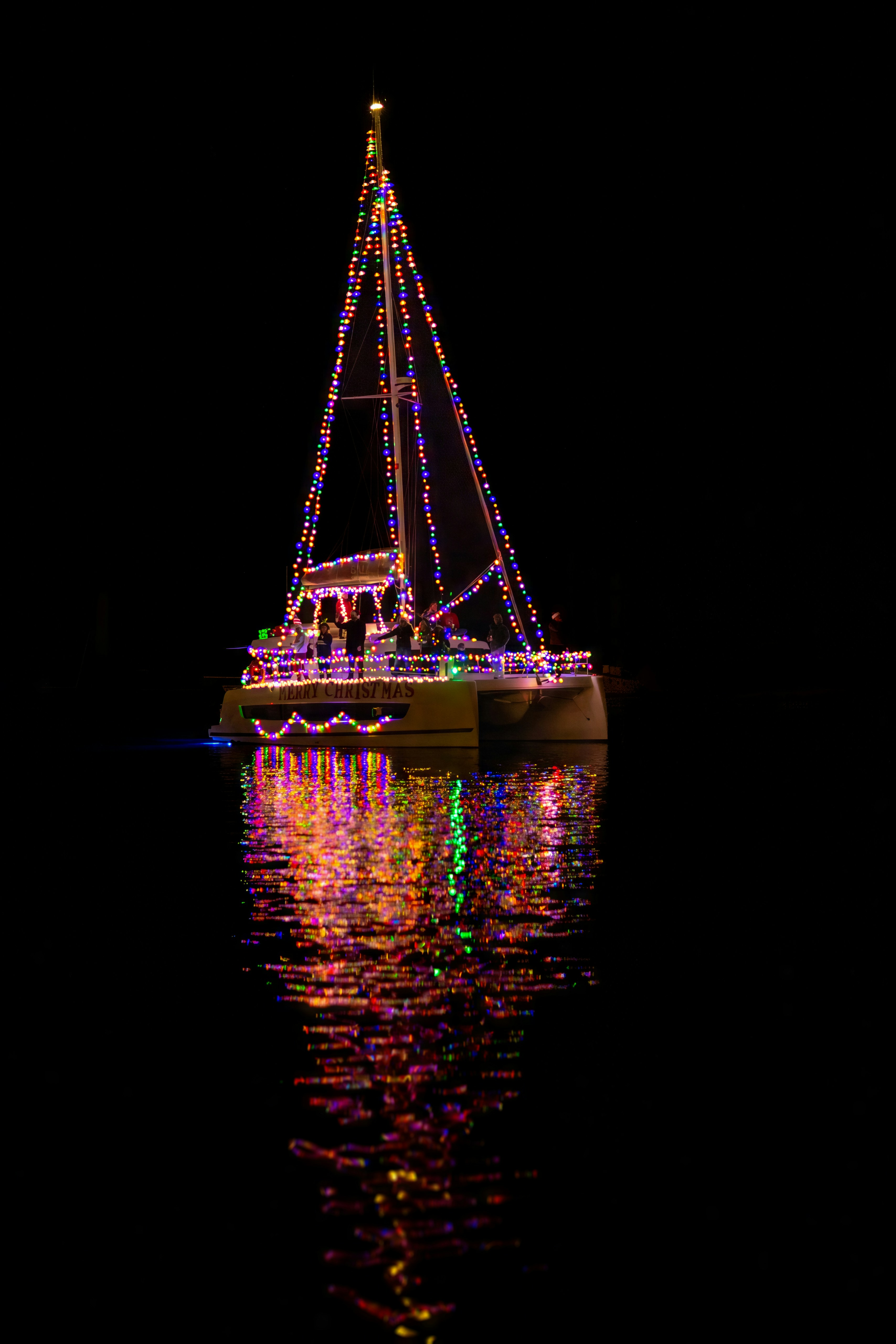 Una barca a vela decorata con luci colorate di notte