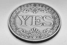 A silver coin with the word yes engraved.