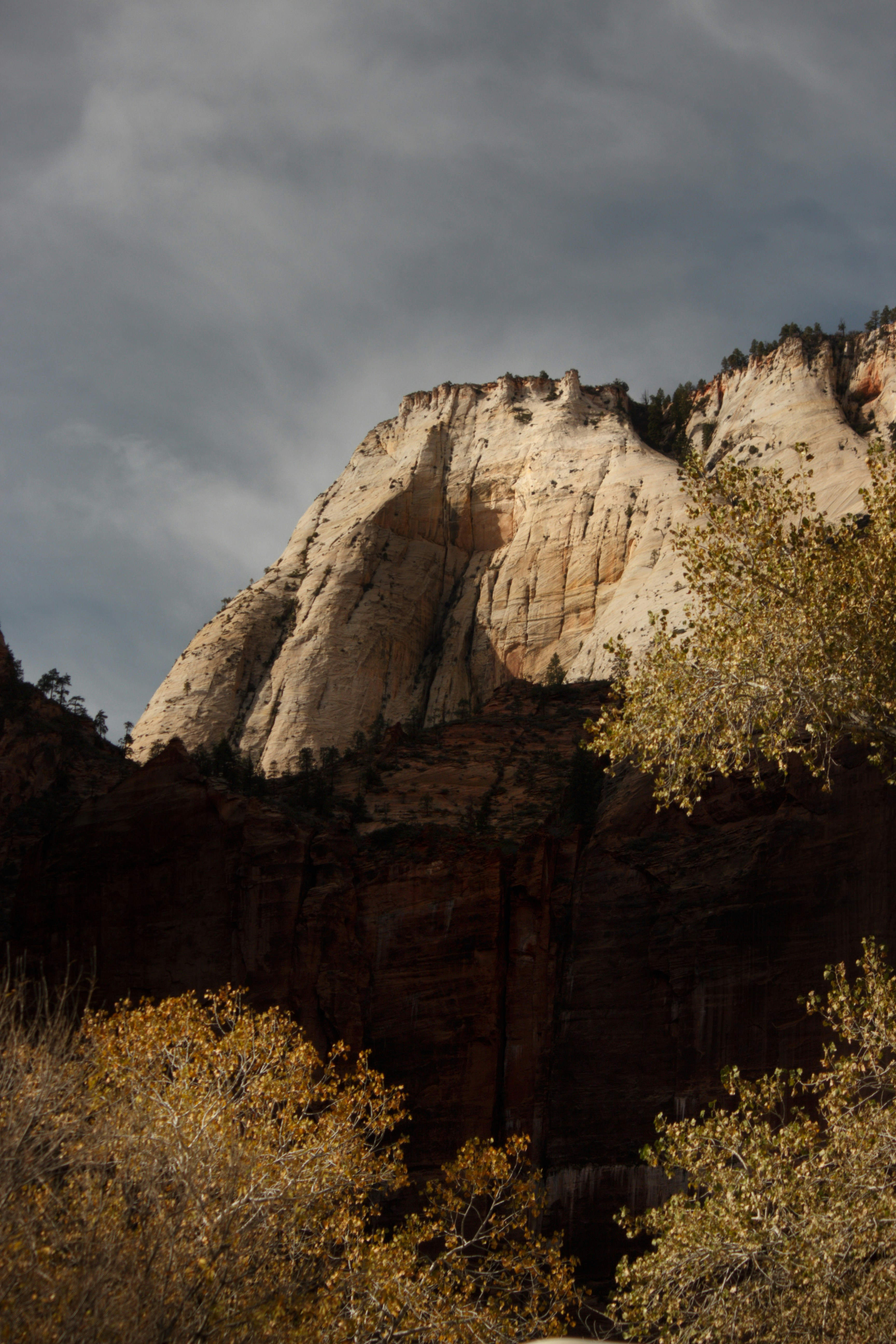 Sunlit sandstone cliffs under a cloudy sky