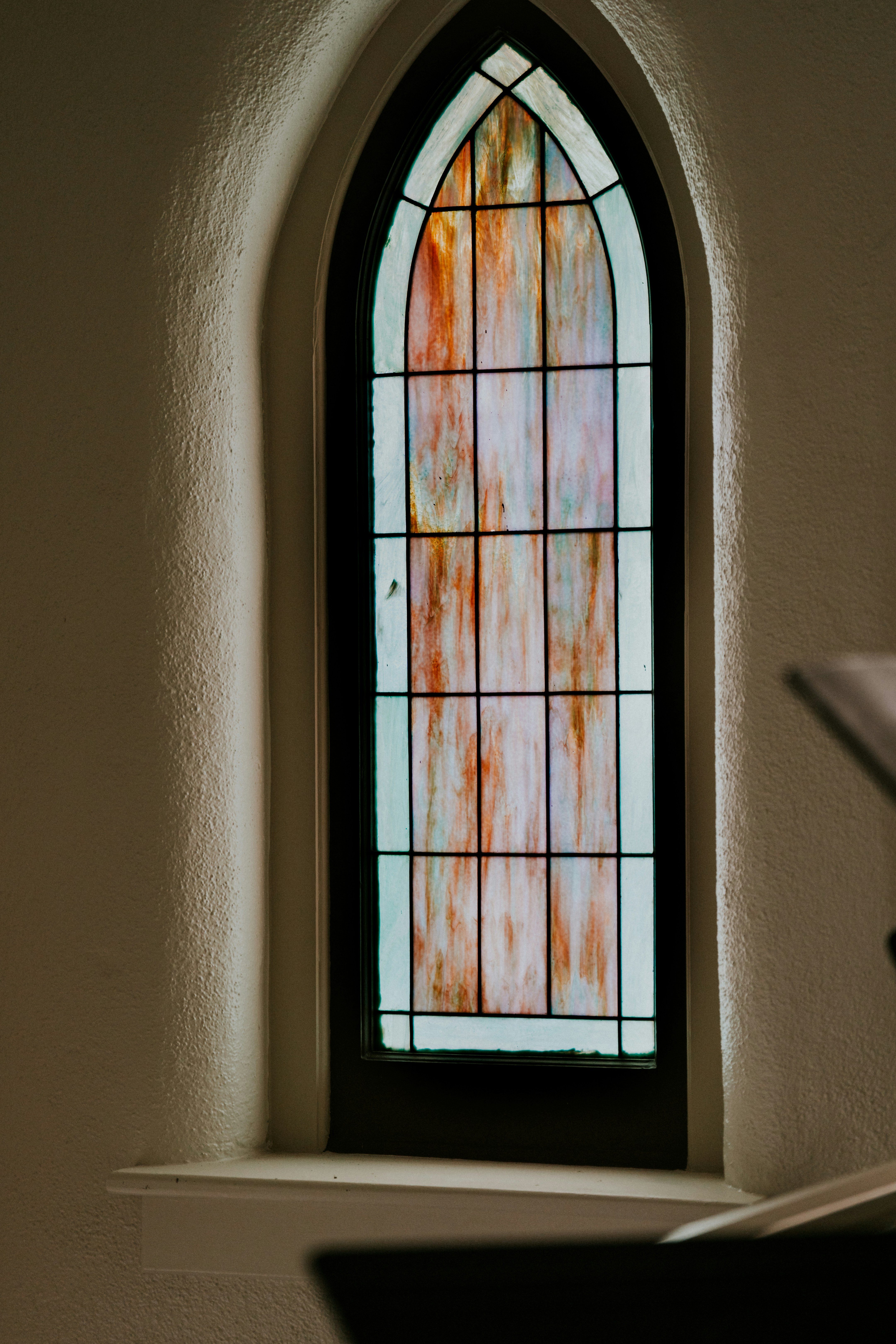 Arched stained glass window with muted colors