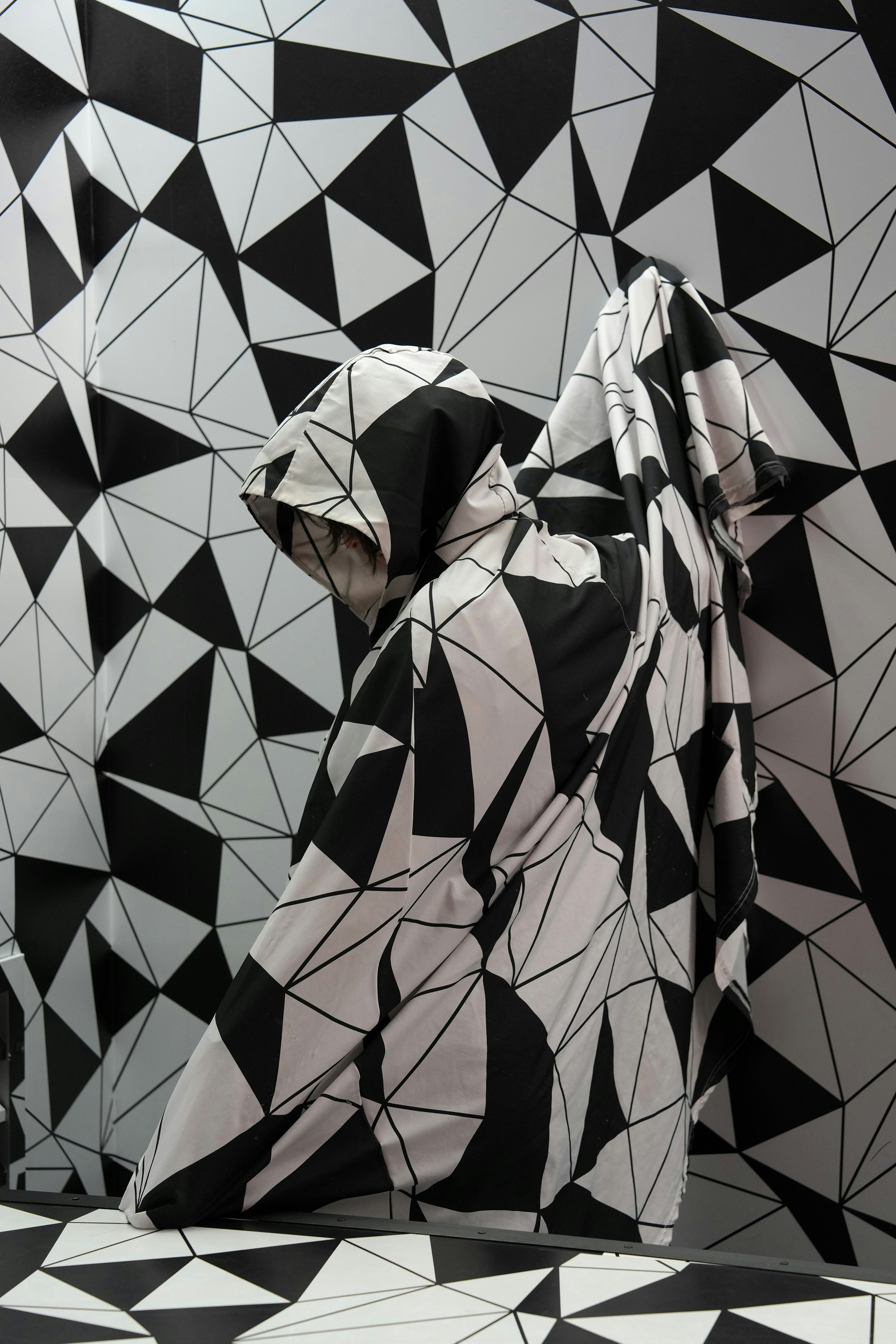Black and white geometric pattern on fabric and wall.