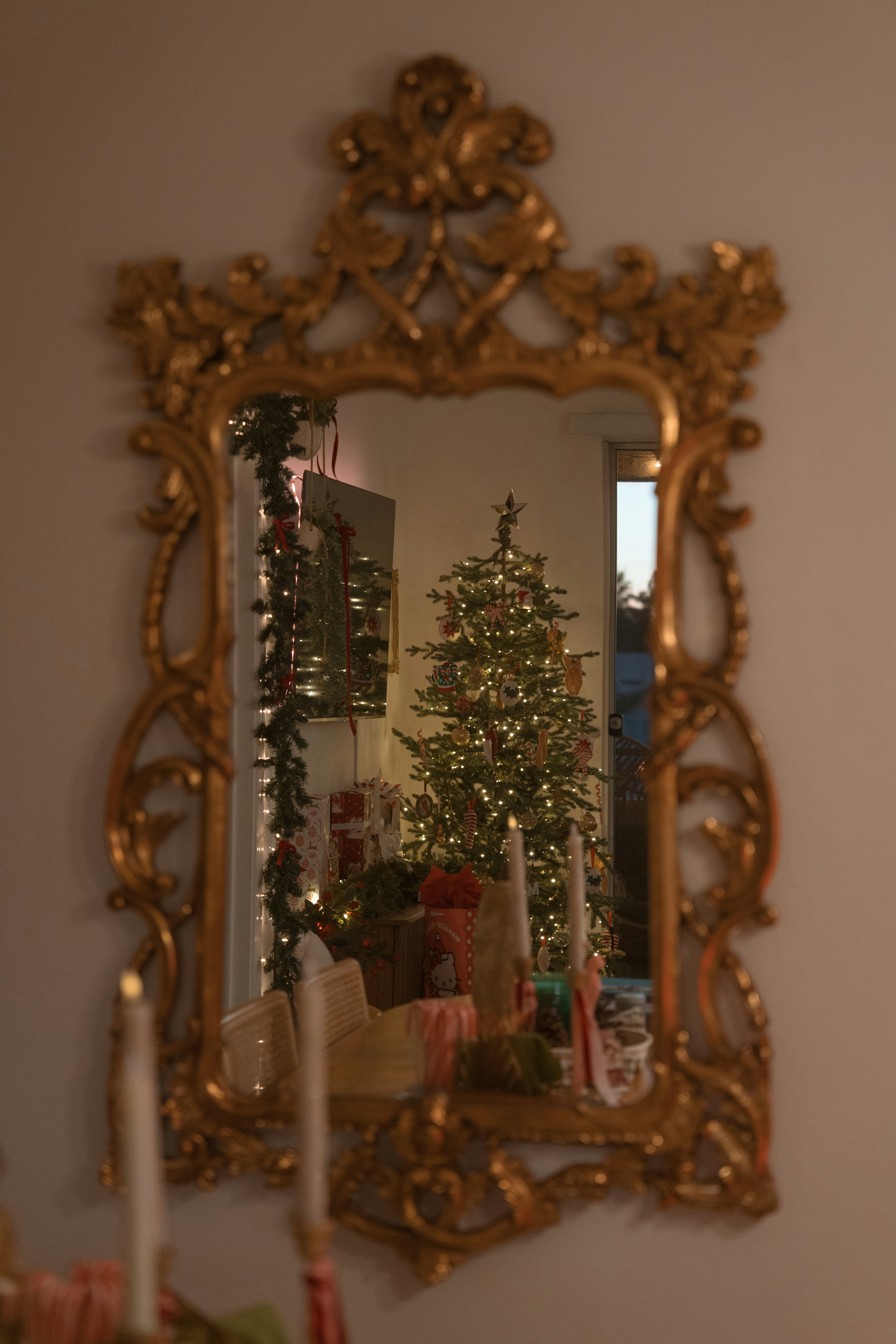 Der kunstvolle Spiegel zeigt einen geschmückten Weihnachtsbaum und Geschenke.