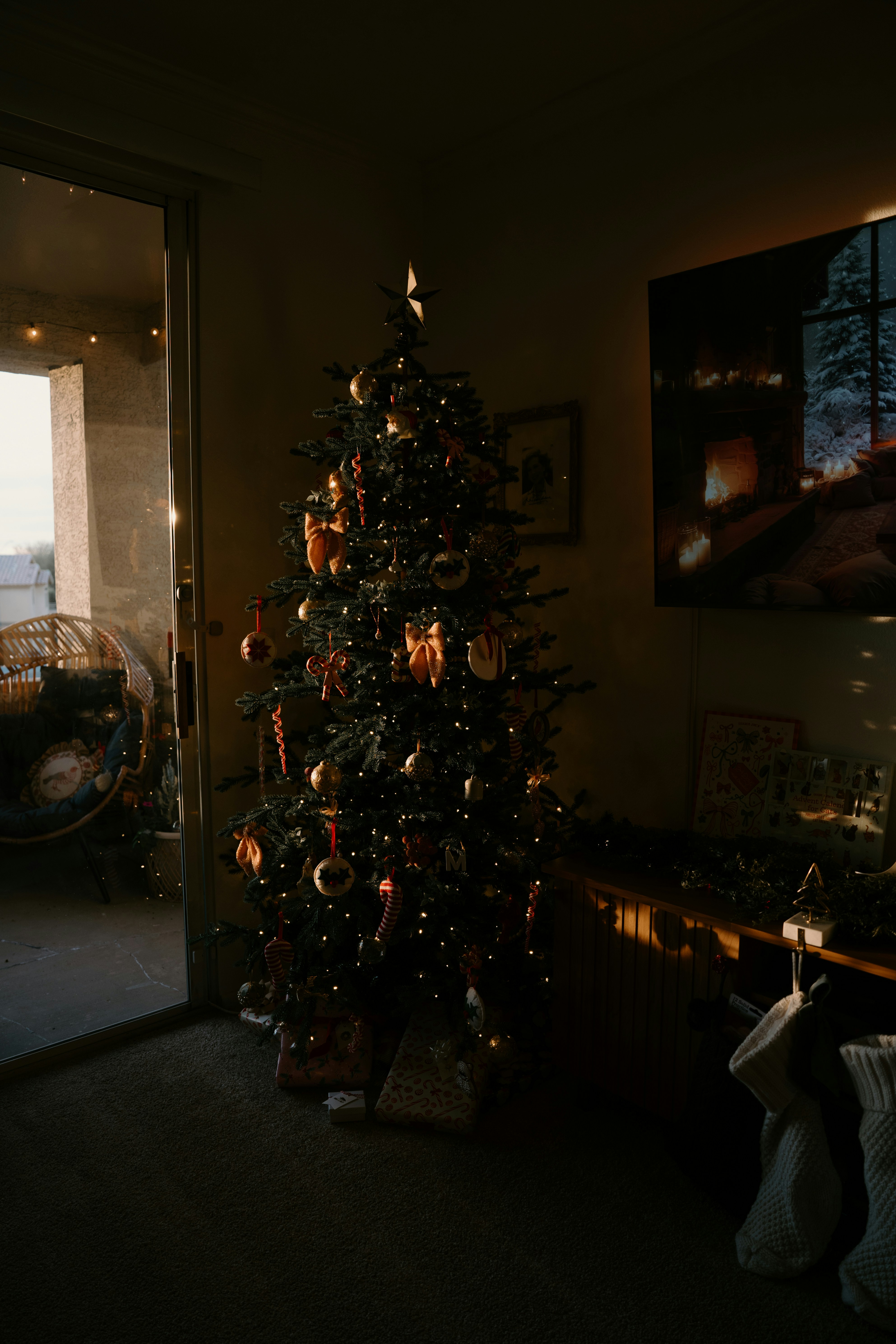 Árbol de Navidad decorado con luces en una habitación tenuemente iluminada.