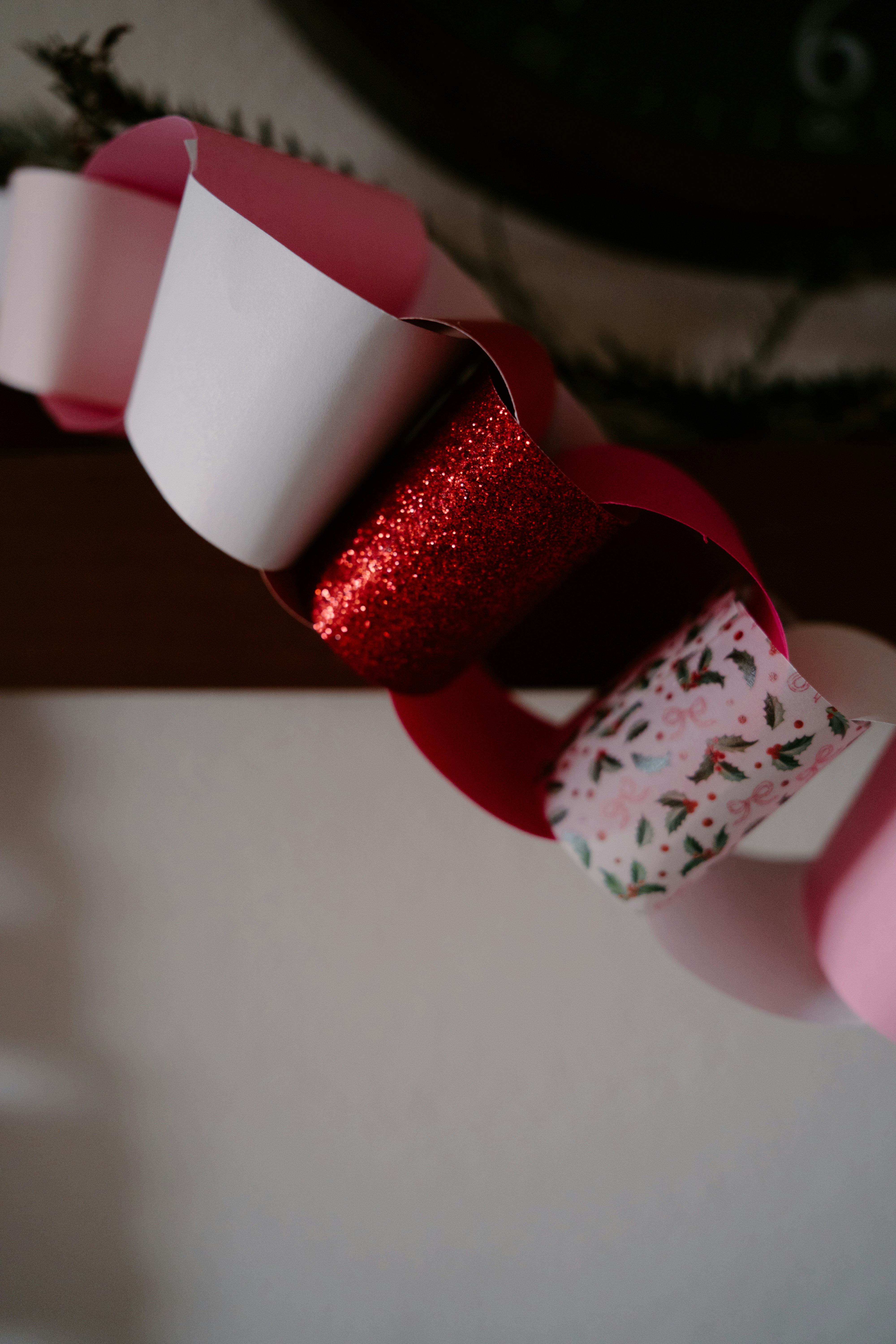 赤いグリッターと華やかな柄が入った紙のチェーンガーランド。