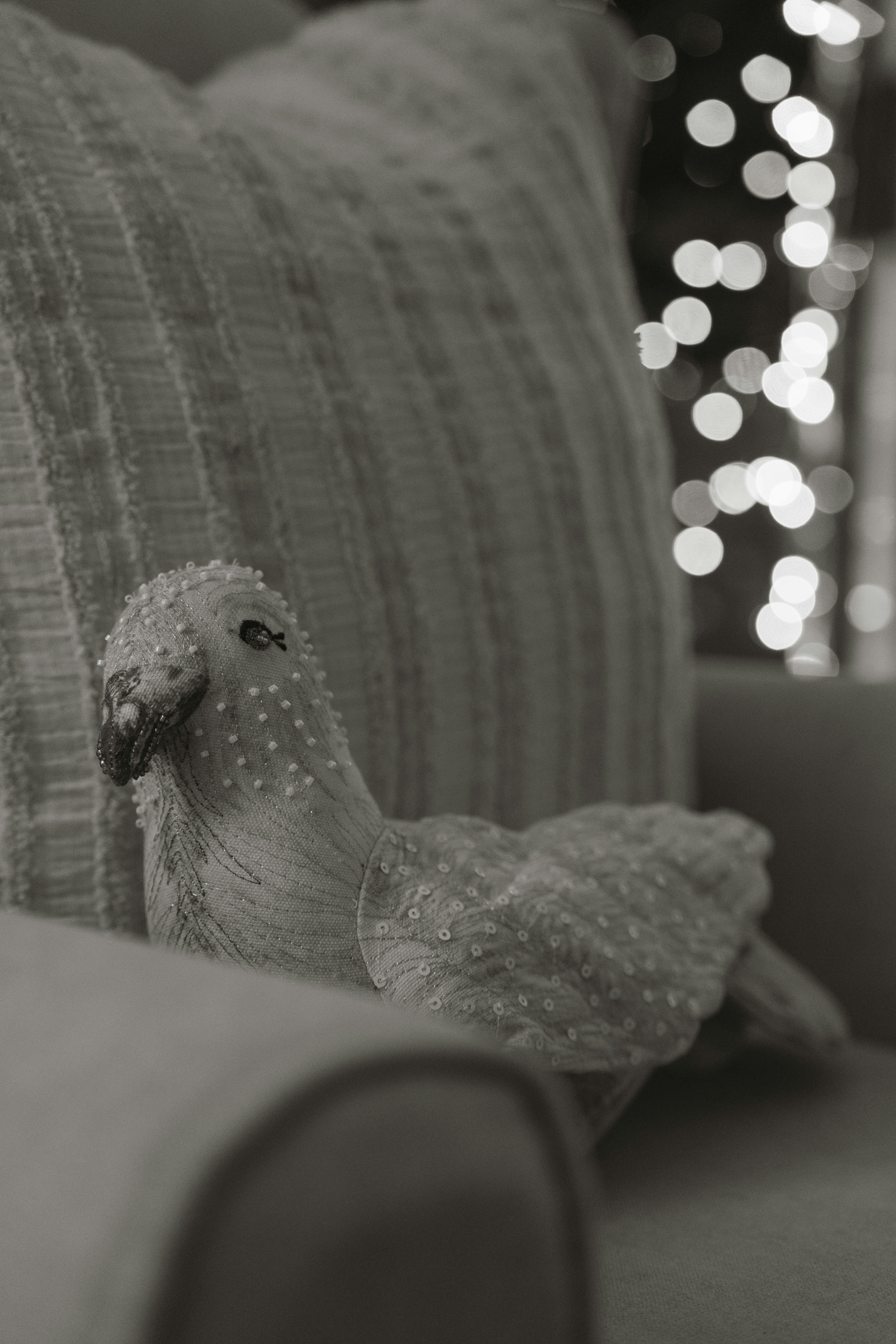 A decorative bird ornament rests on a sofa.
