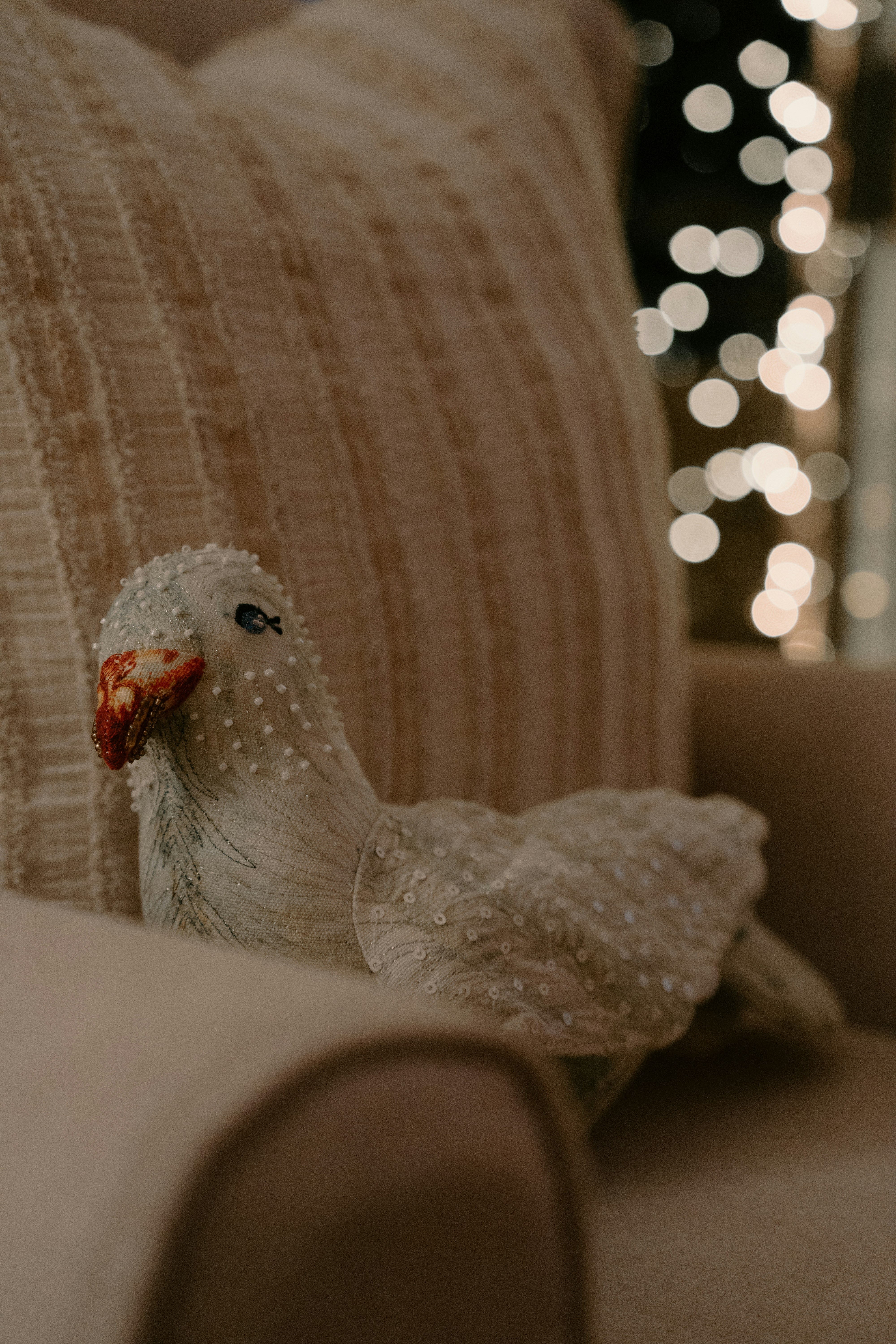 A decorative white bird ornament rests on a chair.