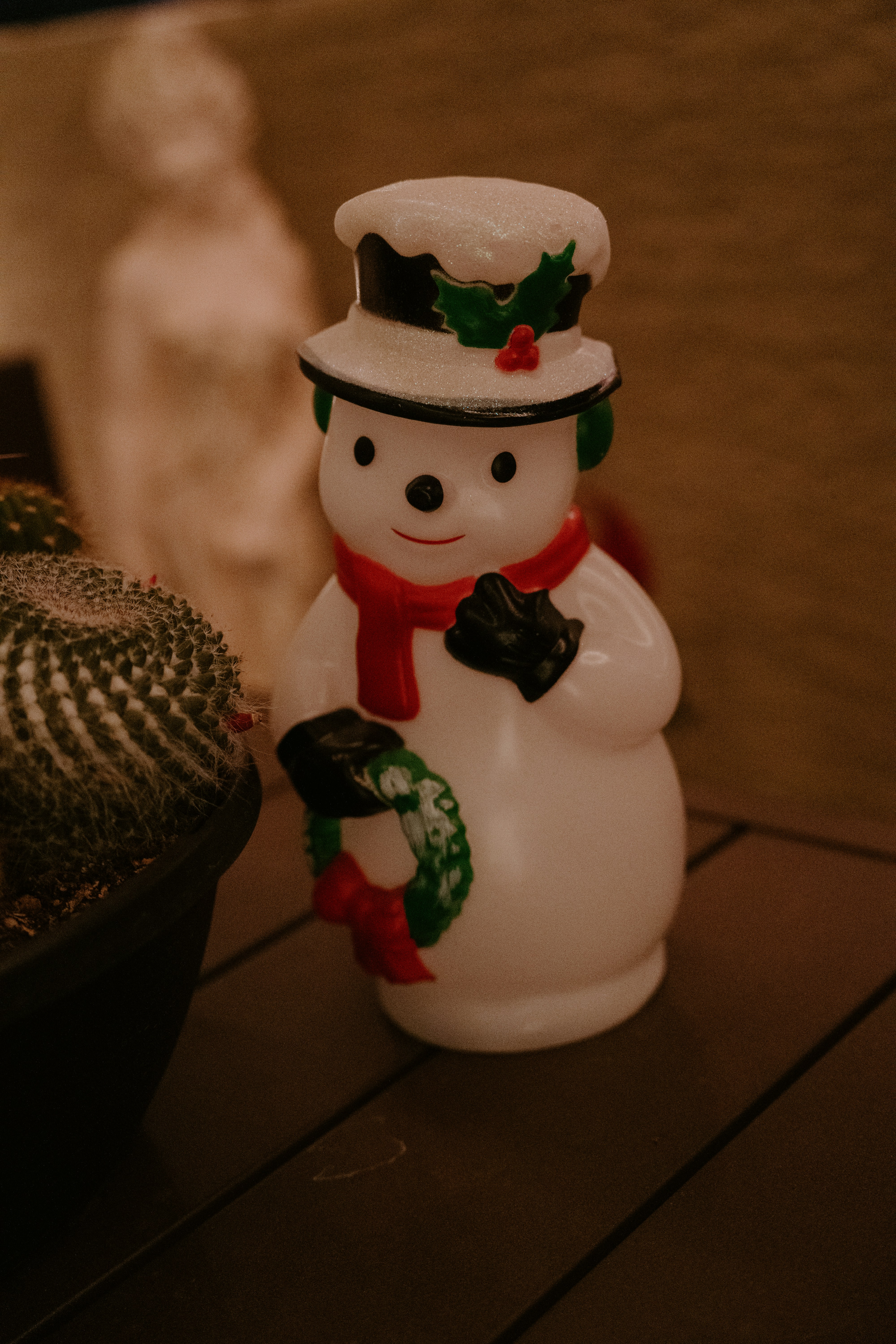 A plastic snowman decoration with a red scarf.