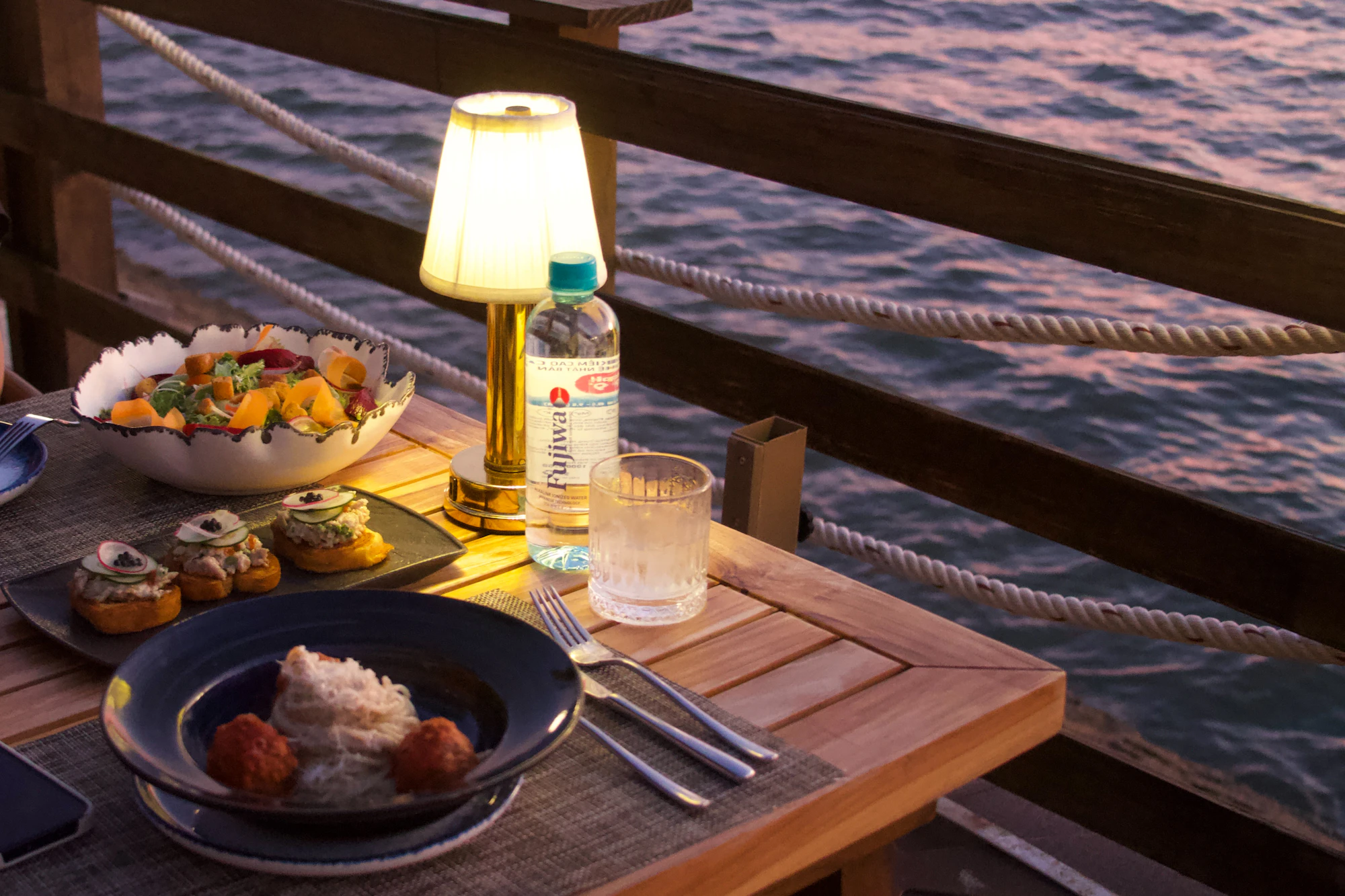 Table set beside the water at dusk