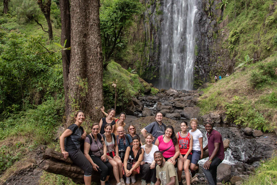 Guests with their guide at the foot of a waterfall near Moshi