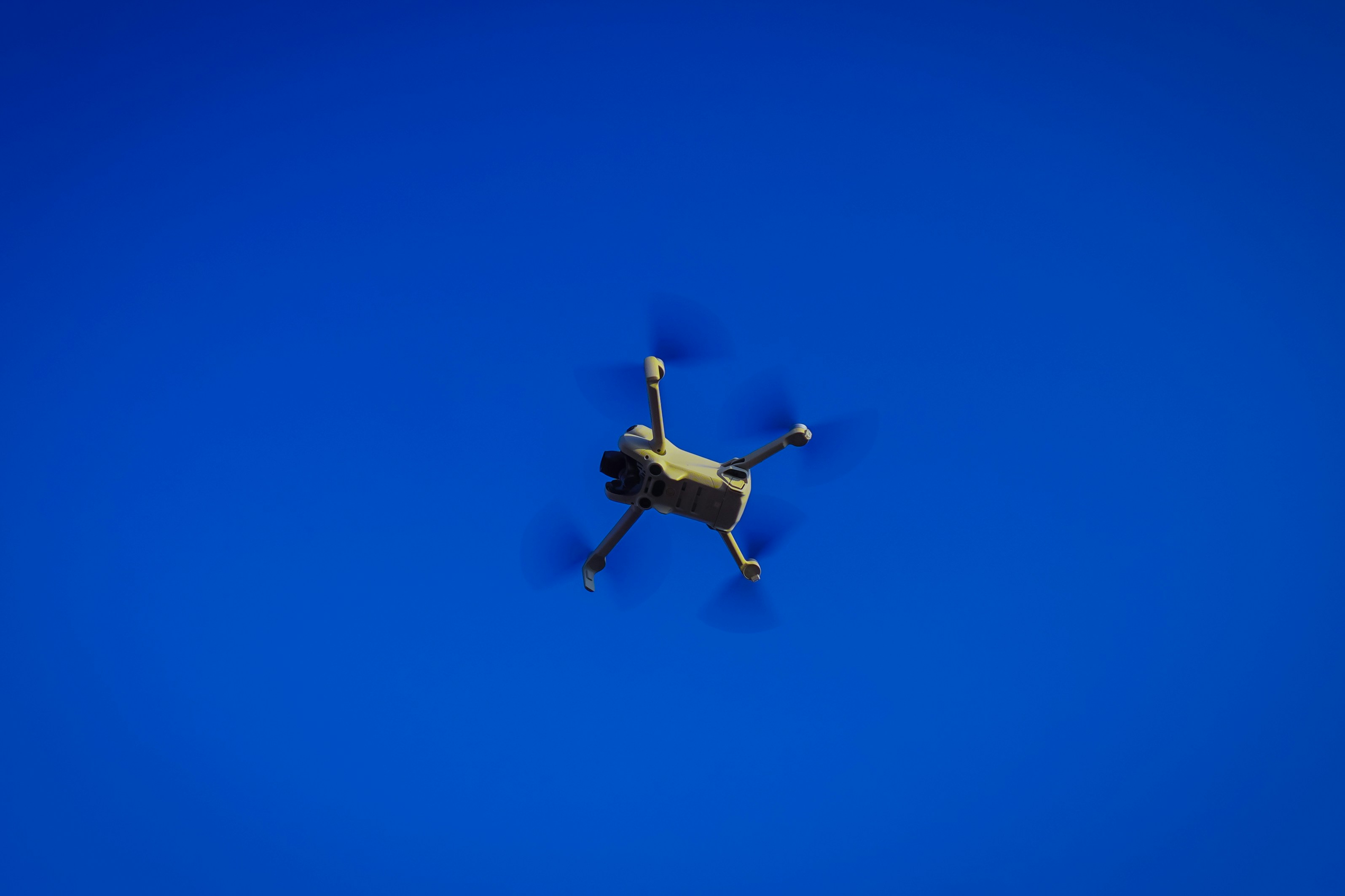 Un dron vuela contra un cielo azul despejado