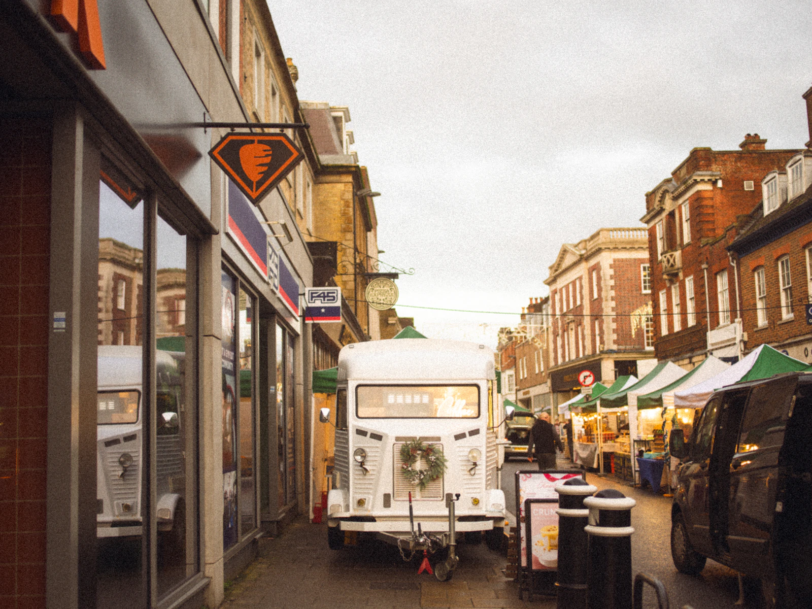 A festive street market with wooden stalls and a food truck