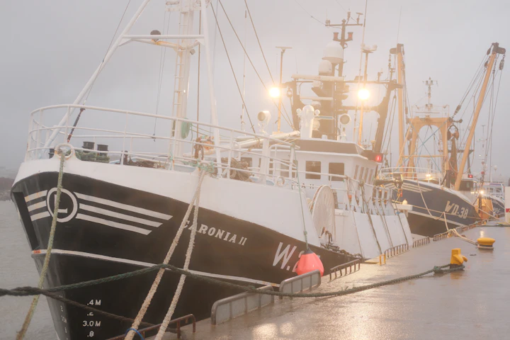 A fishing trawler at rest in a misty Irish harbor at Dunmore East, County Waterford