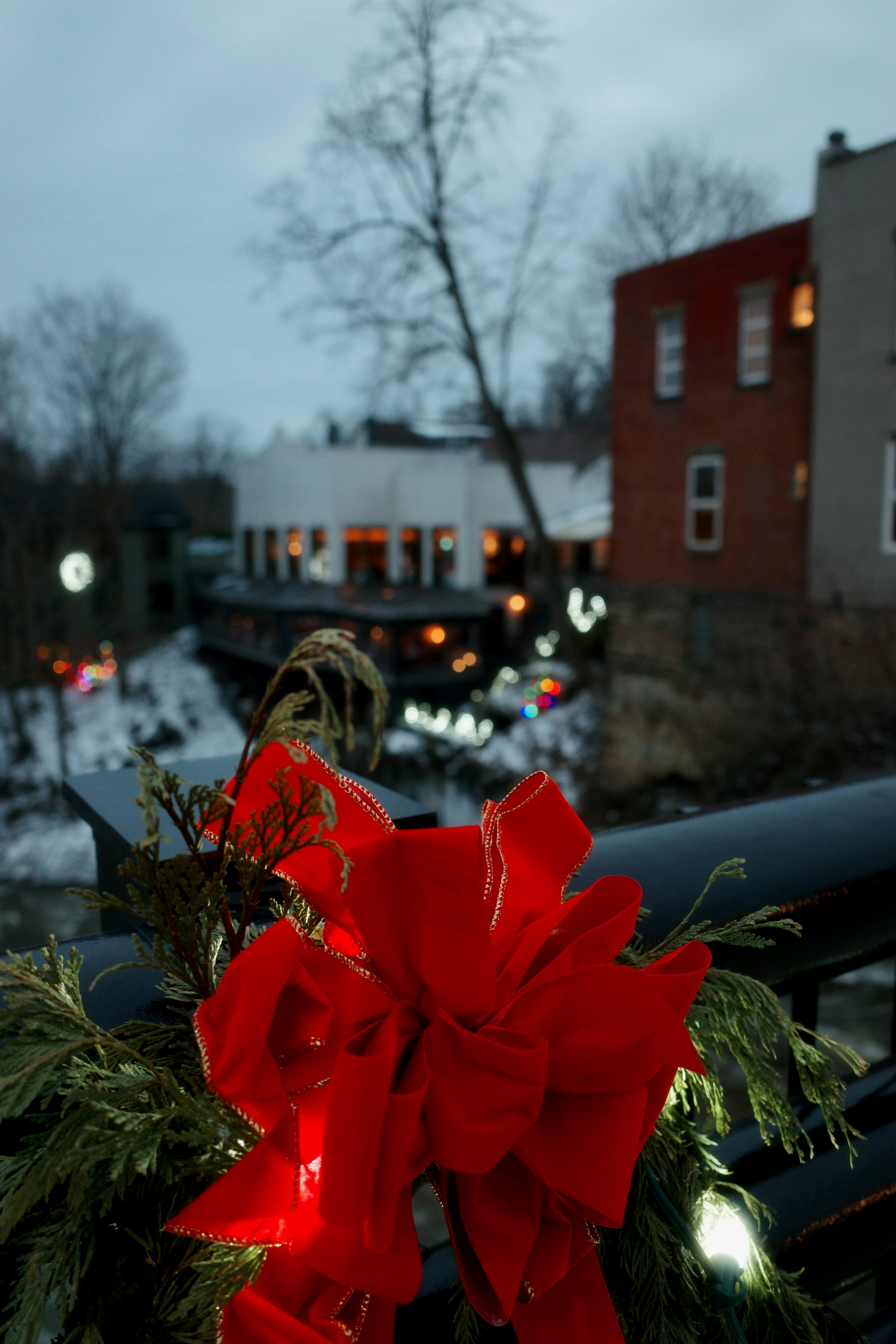 Decorazione a fiocco rosso su una ringhiera con luci festive