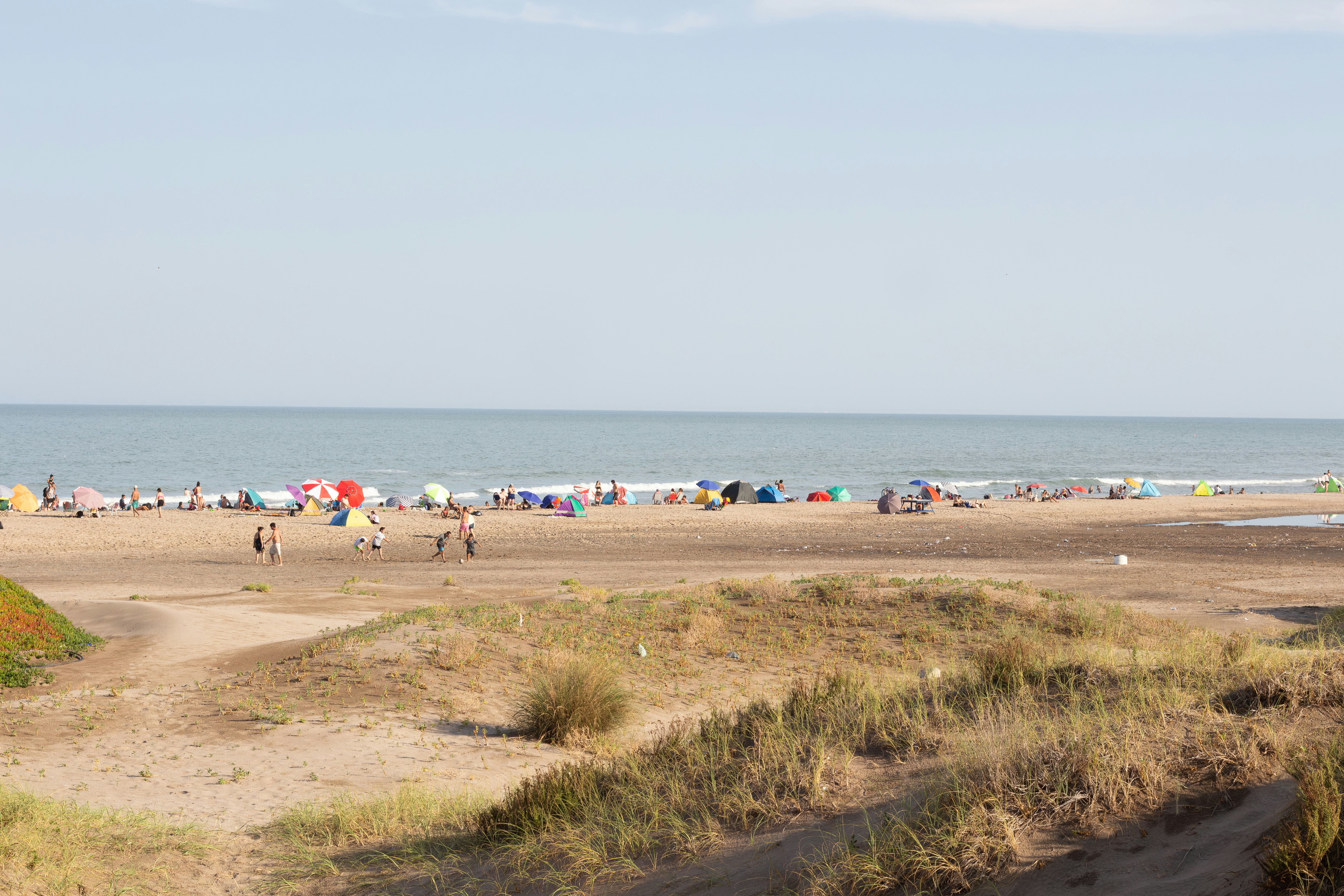 People relaxing on a sandy beach with ocean waves.