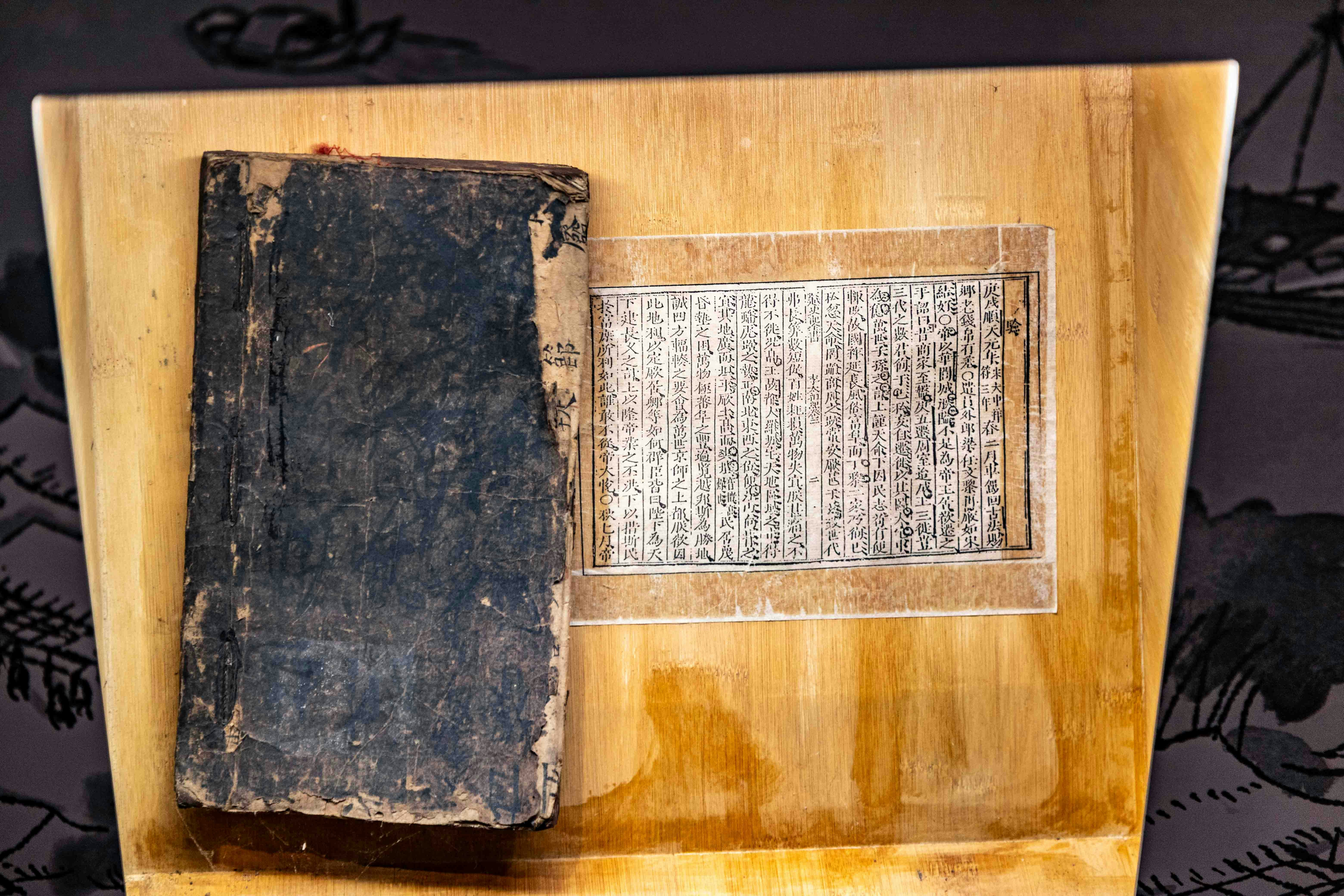 A pair of antique-style weighing scales. On one side, a scroll labeled 