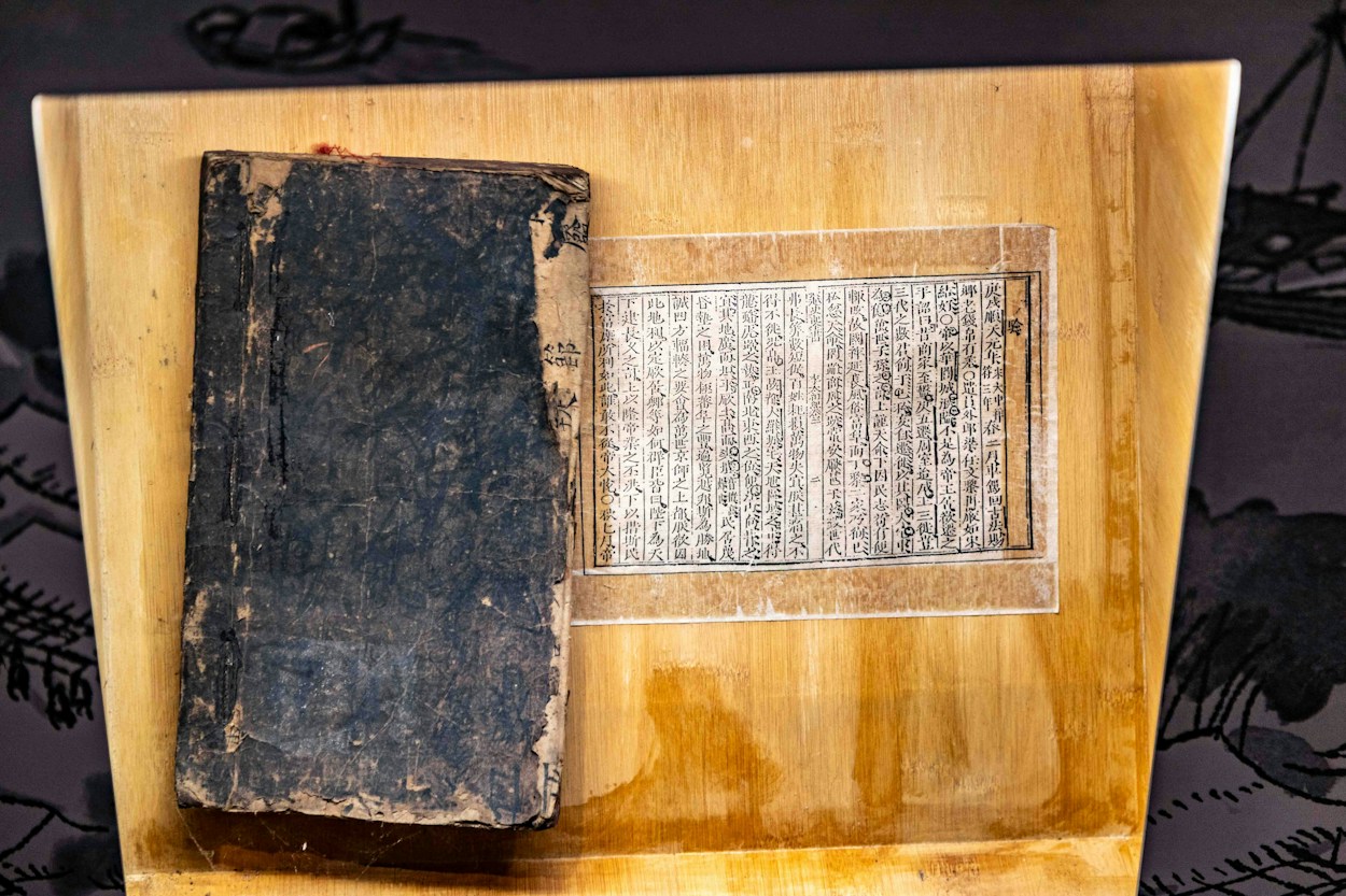 Libro antiguo y manuscritos que evocan un archivo de estudio