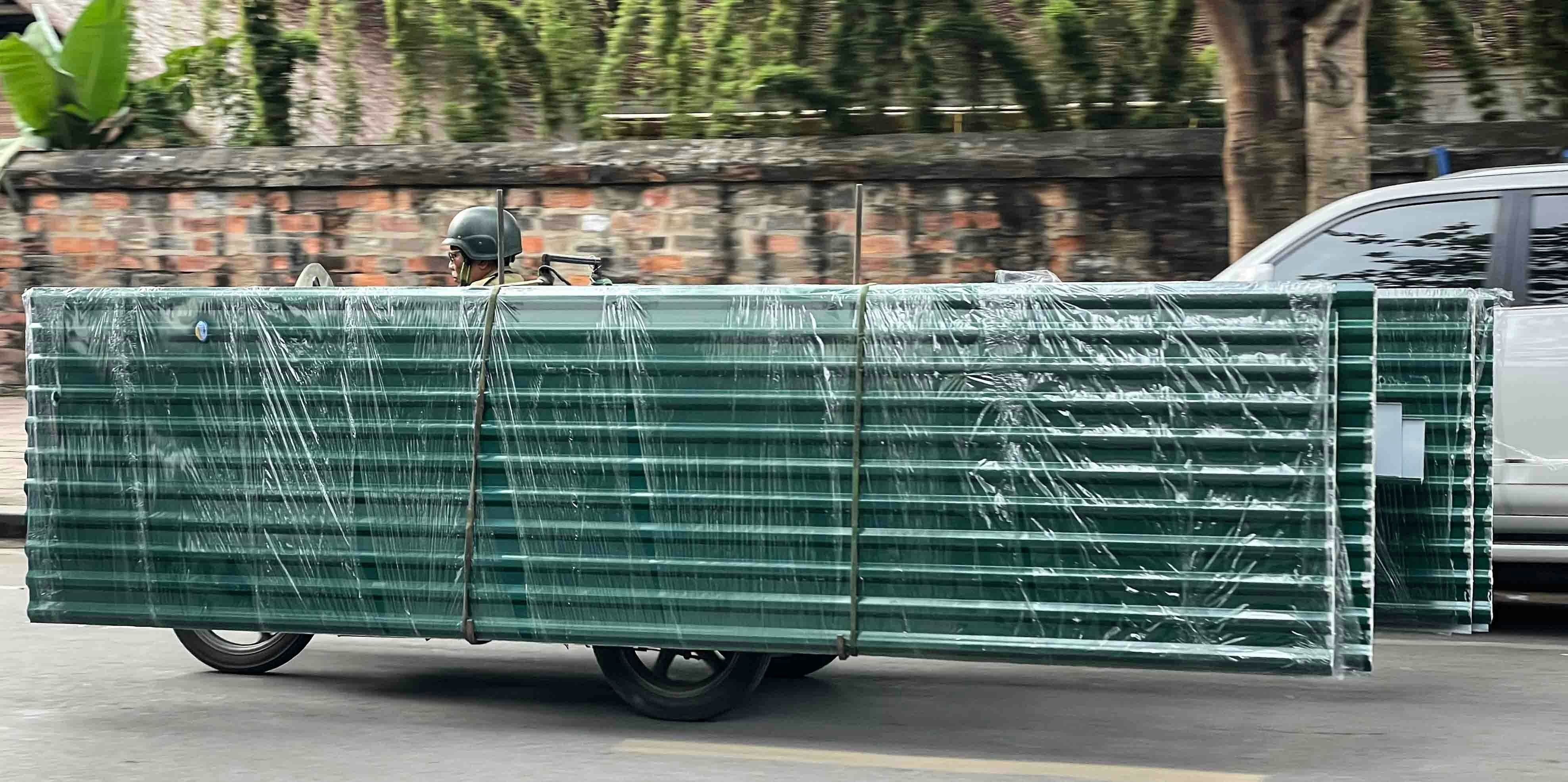 Green metal panels stacked on a cart
