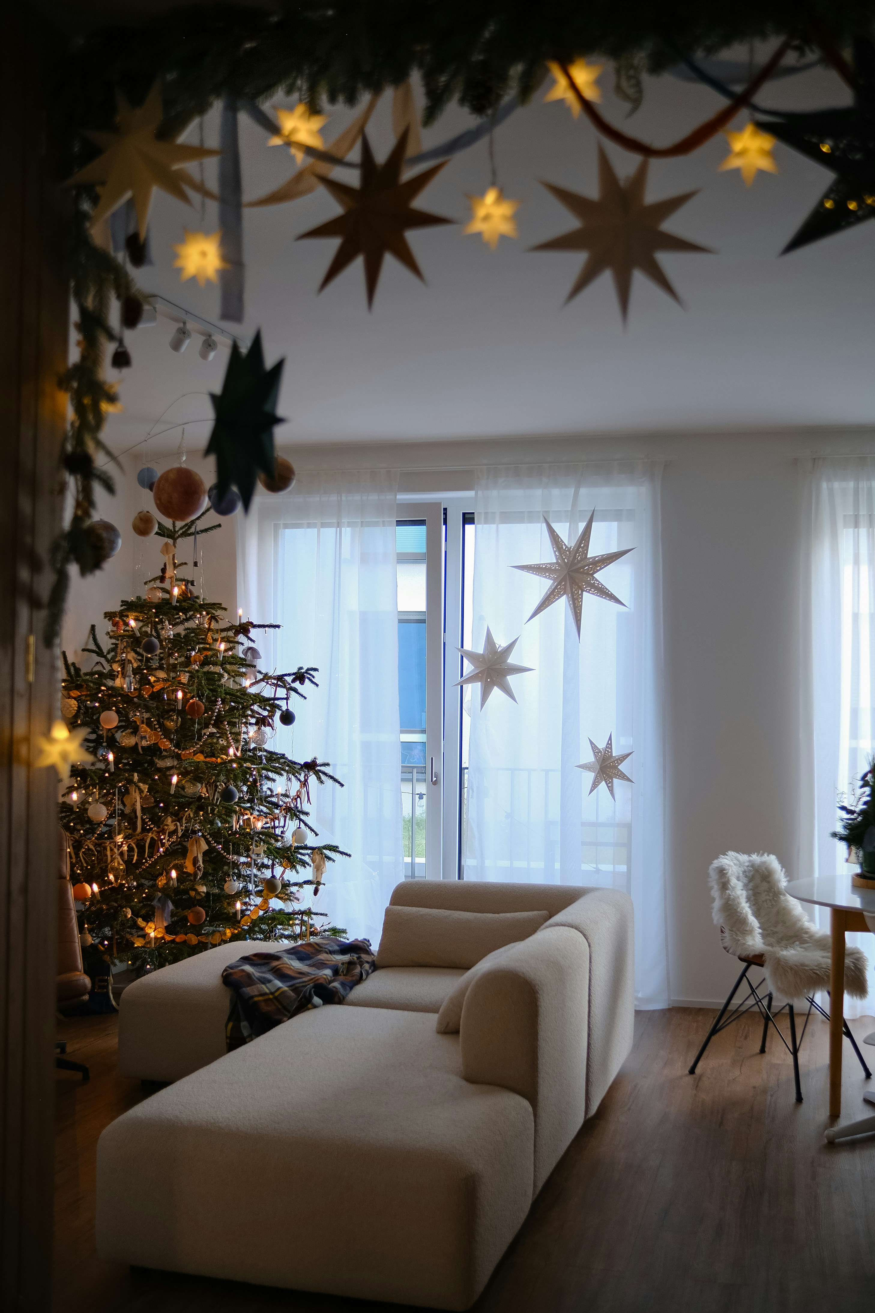 Cozy living room decorated for christmas with a tree.