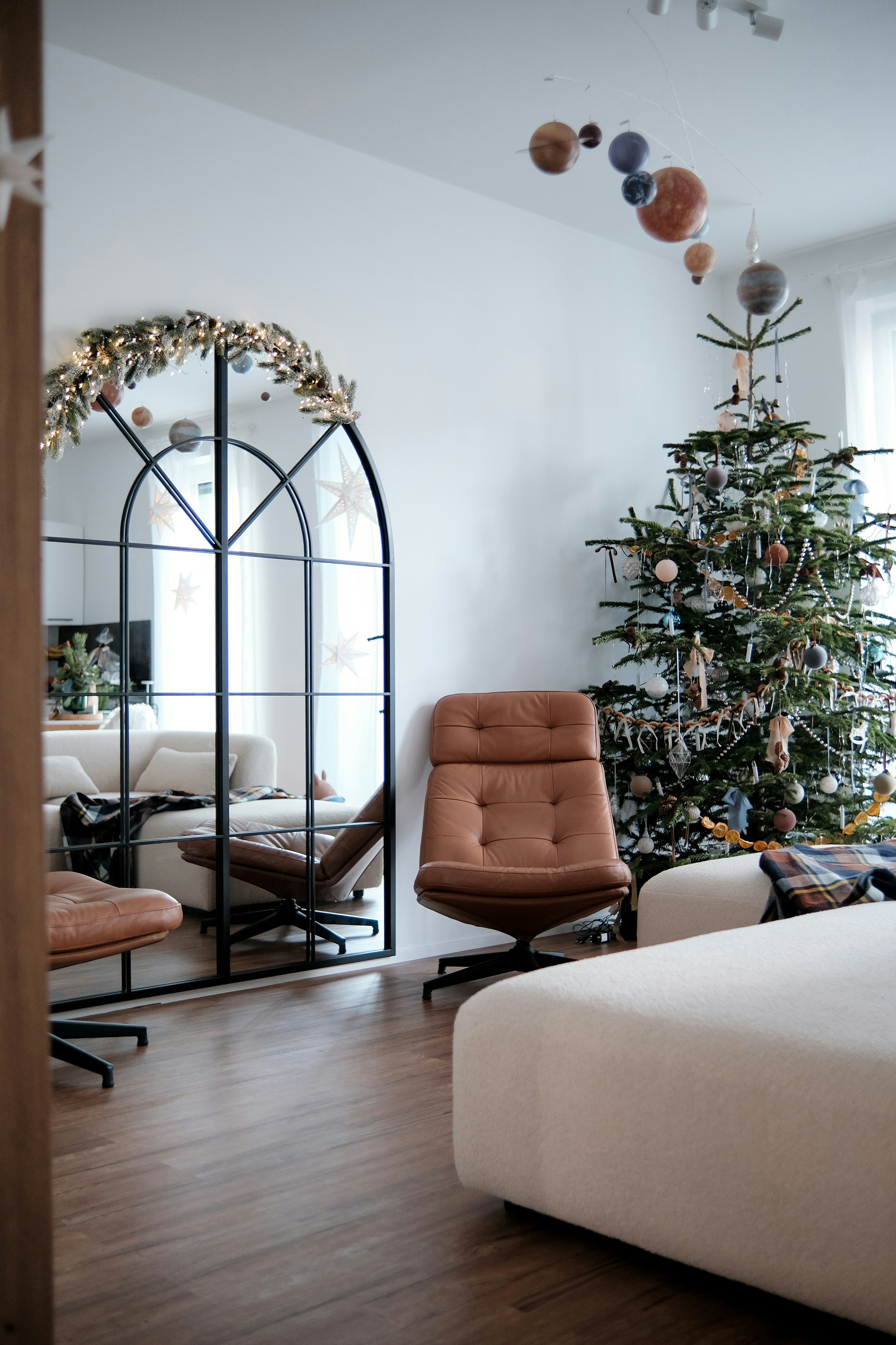 A living room decorated for christmas with a tree.