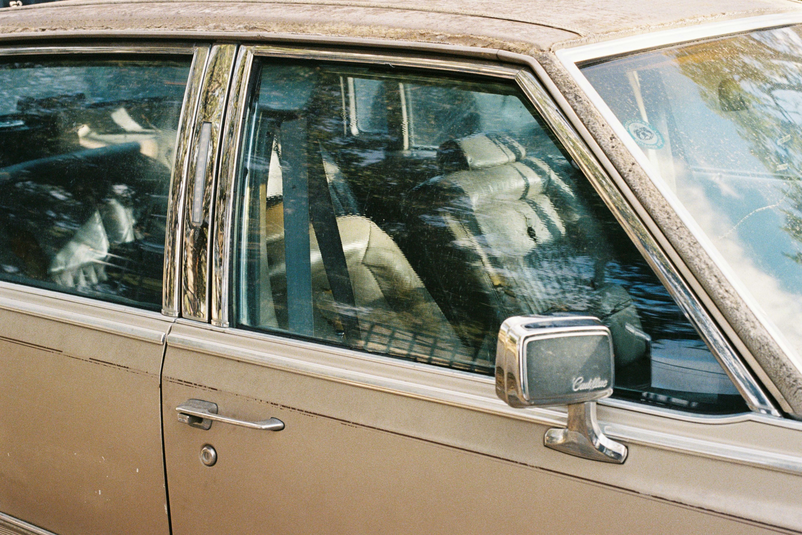 Interior of a vintage car with dusty windows.