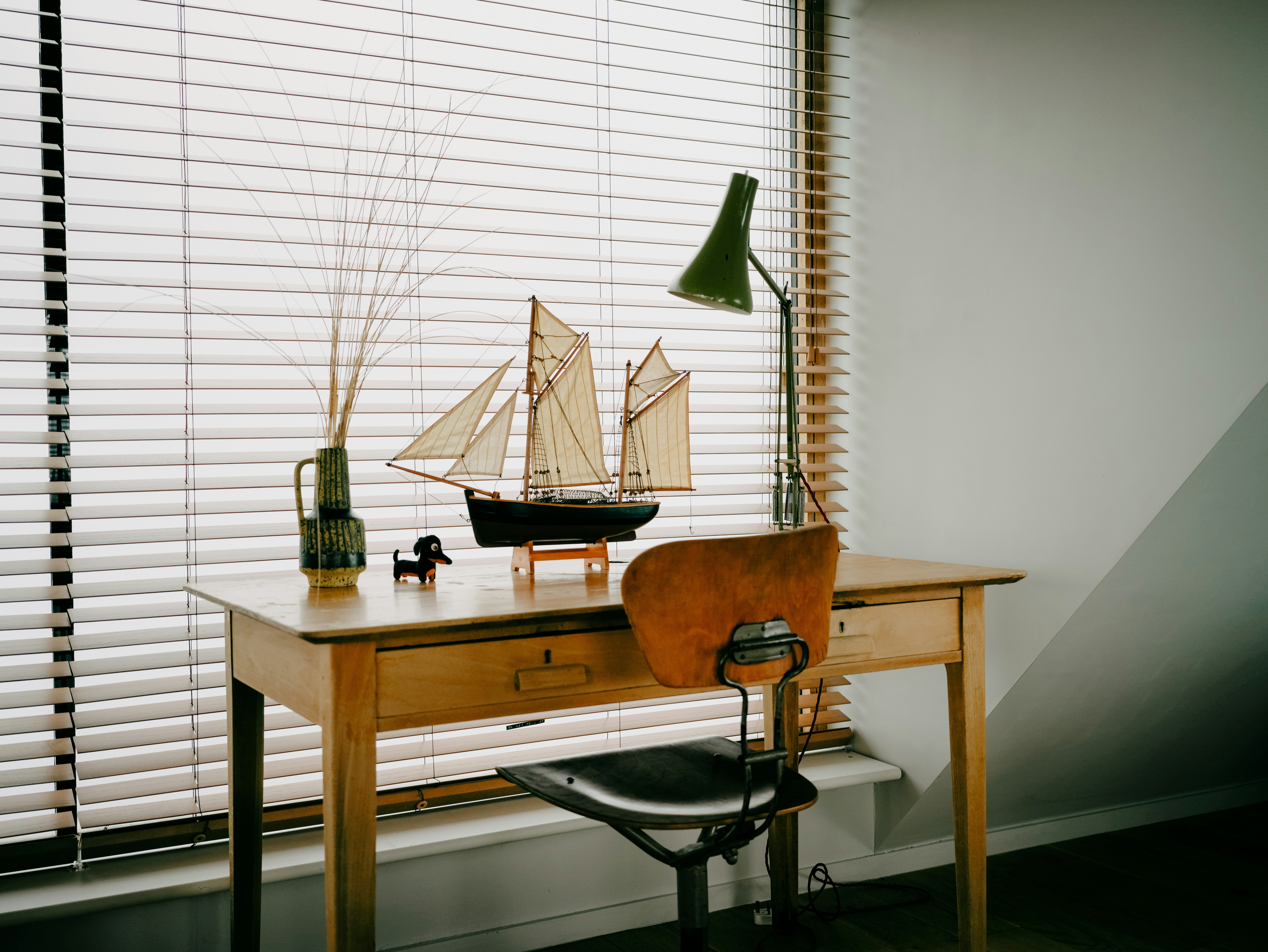 Desk with model sailboat and lamp