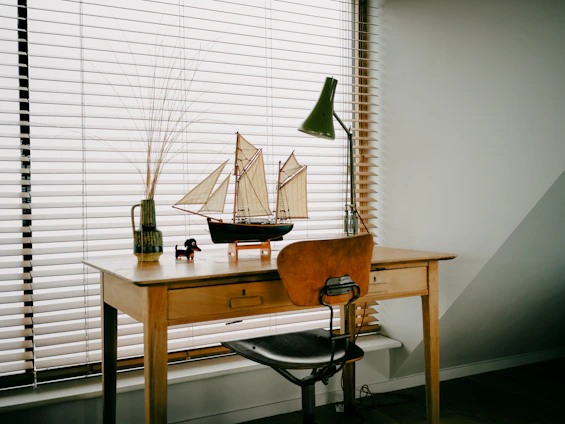 Desk with model sailboat and lamp