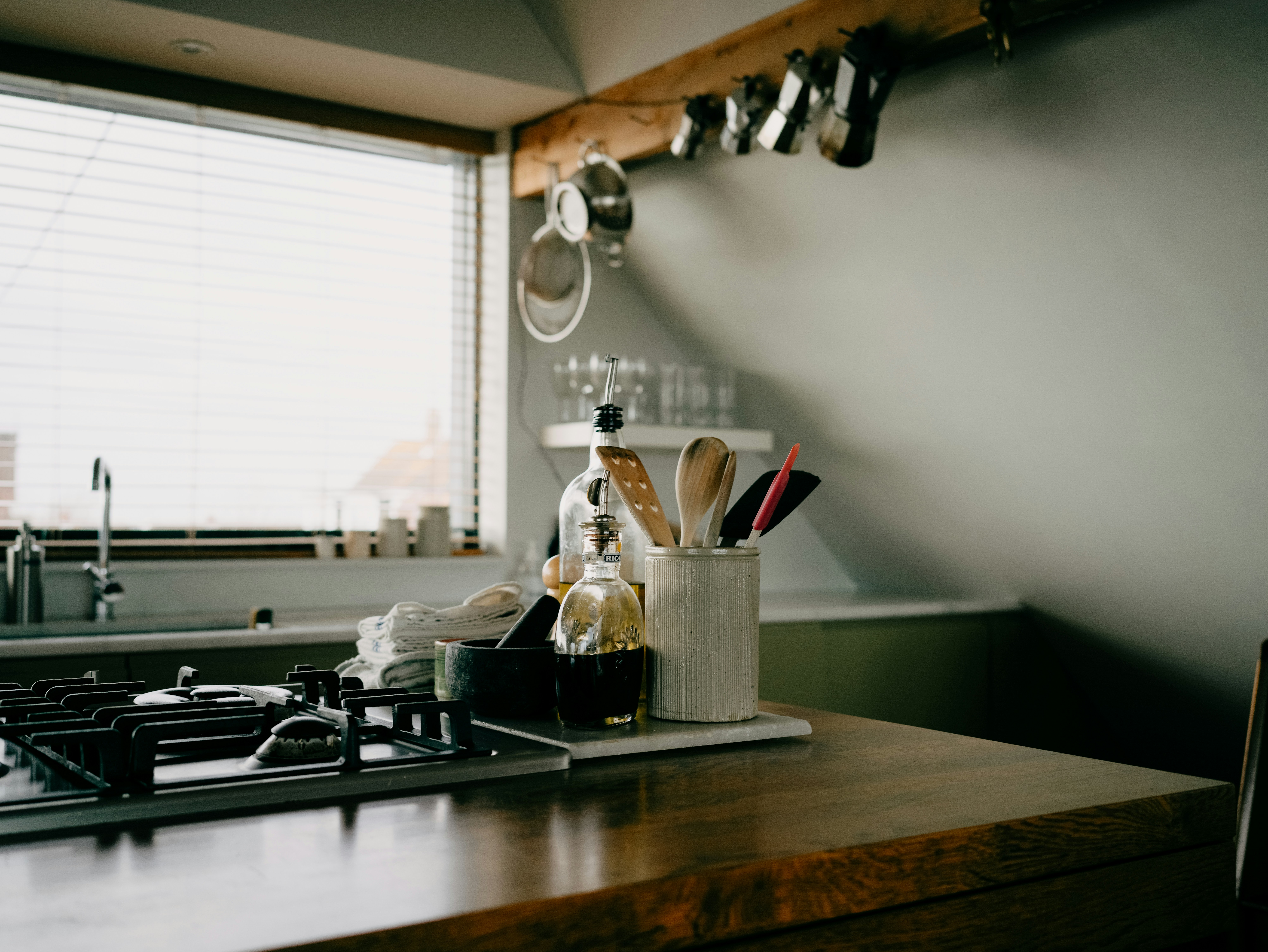 Kitchen counter with cooking utensils and stove.