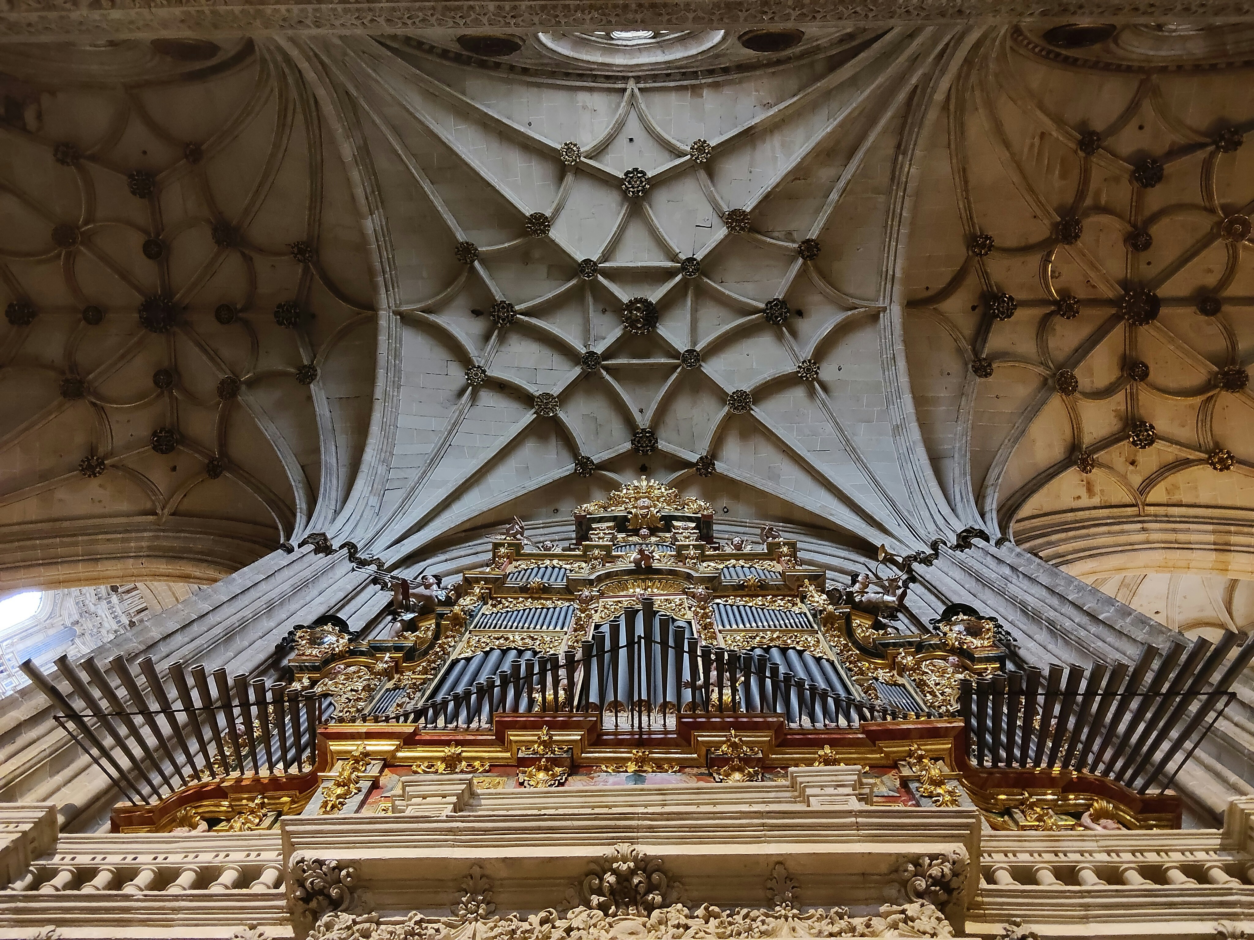 Ornate pipe organ beneath a grand vaulted ceiling.