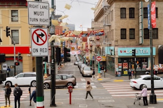 Street scene in a bustling city with cars and pedestrians.