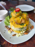 Layered dish with fish, corn, and lettuce