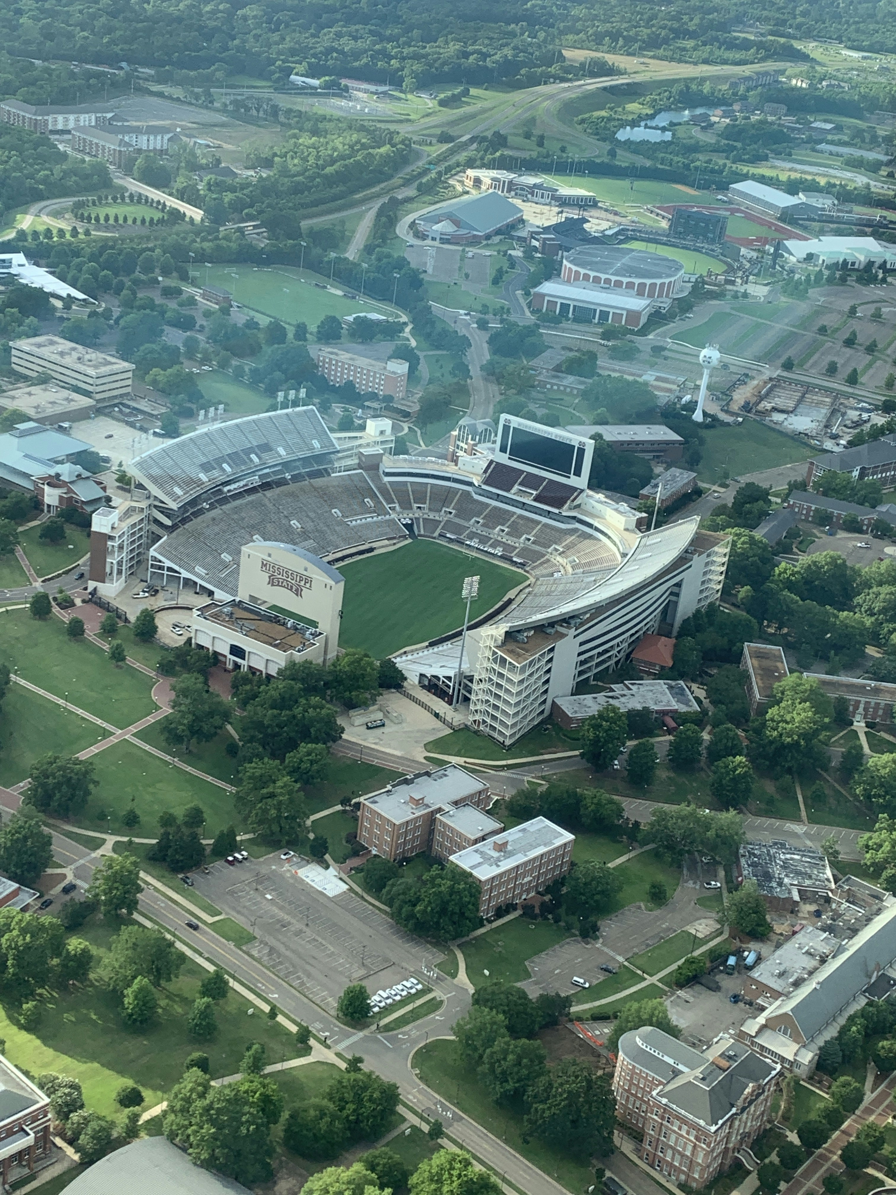 Aerial view of a large sports stadium and surrounding campus.